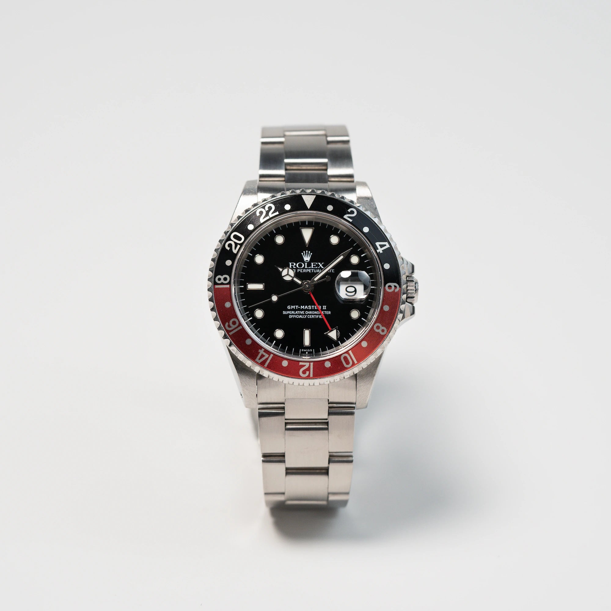 Frontale Ansicht der Rolex GMT Master 2 (Referenz 16710) mit der Coke-Lünette in schwarz-rot mit dem "Swiss-Only" Zifferblatt