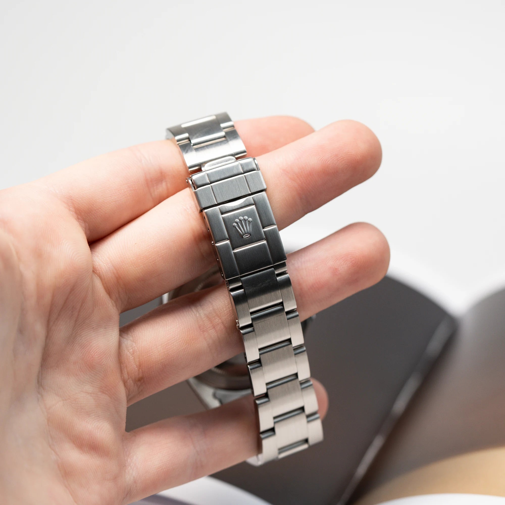 Mann hält die Rolex GMT Master 2 (Referenz 16710) mit der Coke-Lünette in seiner Hand und man blickt auf die Faltschliesse