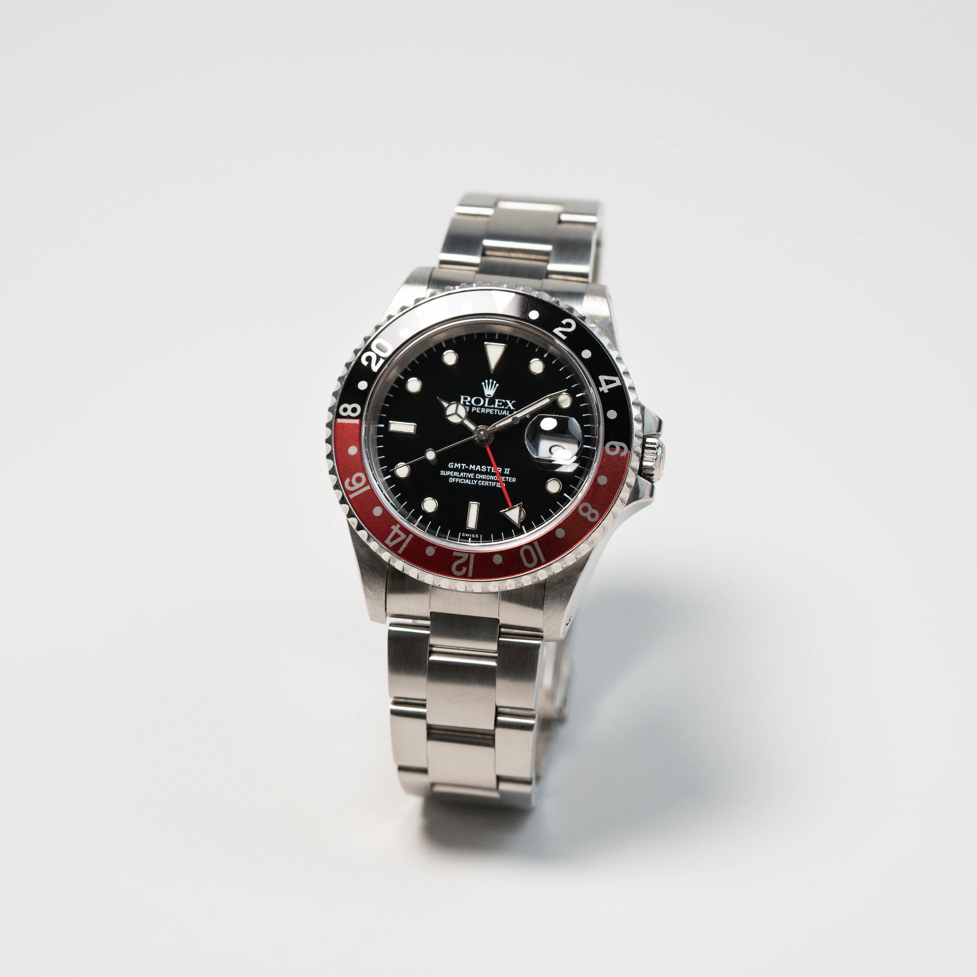 Leicht seitliche Ansicht der Rolex GMT Master 2 (Referenz 16710) mit der Coke-Lünette in schwarz-rot mit dem "Swiss-Only" Zifferblatt
