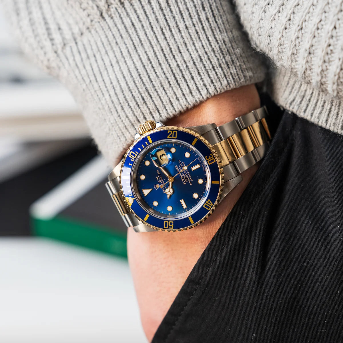 Mann steckt Hand in die Hosentasche und trägt eine Rolex Submariner Bluesy an diesem Handgelenk