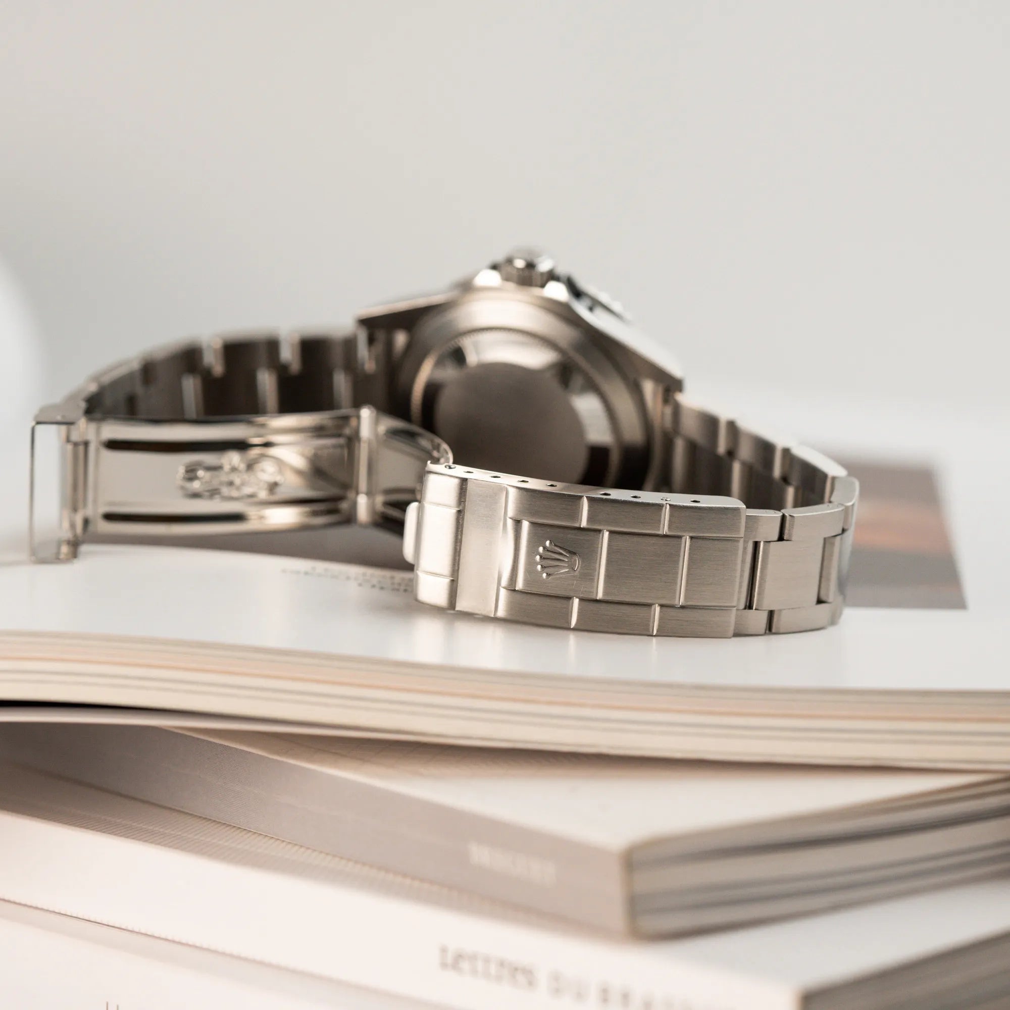 Produktfoto der Rolex Submariner Date Taucheruhr in der ikonischen Kermit-Variante mit einer einzigartigen Lime-Lünette und Fokus auf der geöffneten Faltschliesse