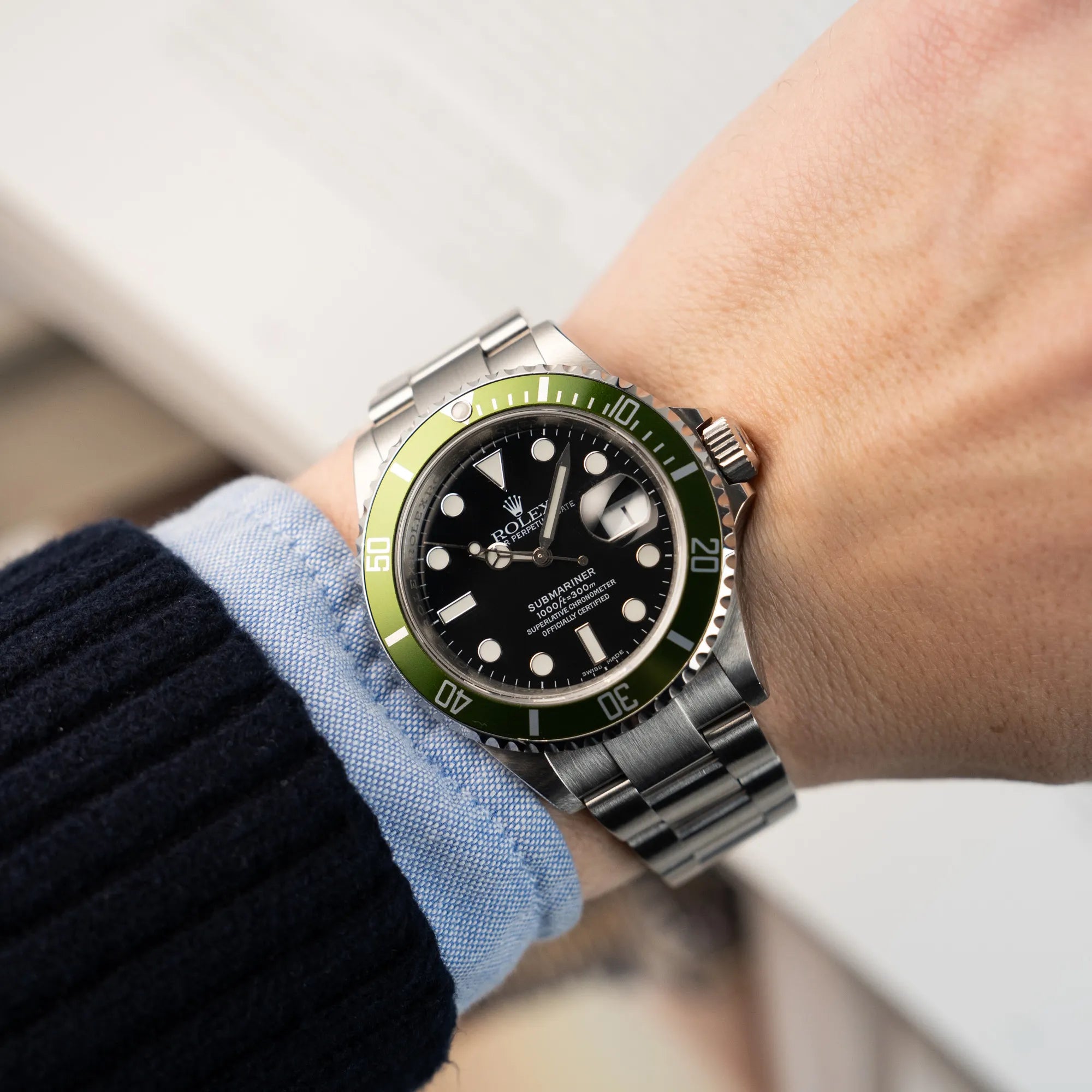 Mann trägt die Rolex Submariner Date Taucheruhr in der ikonischen Kermit-Variante mit einer einzigartigen Lime-Lünette an seinem Handgelenk