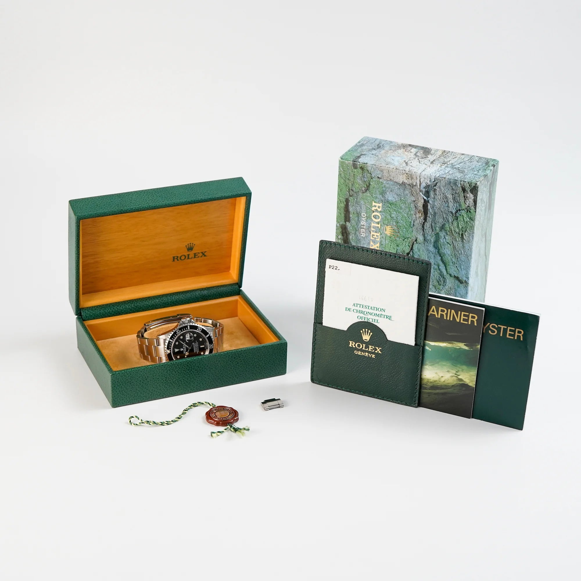 Lieferumfang der Rolex Submariner Date in schwarz, Referenz 16610, mit Flat-Four-Lünette im Full-Set