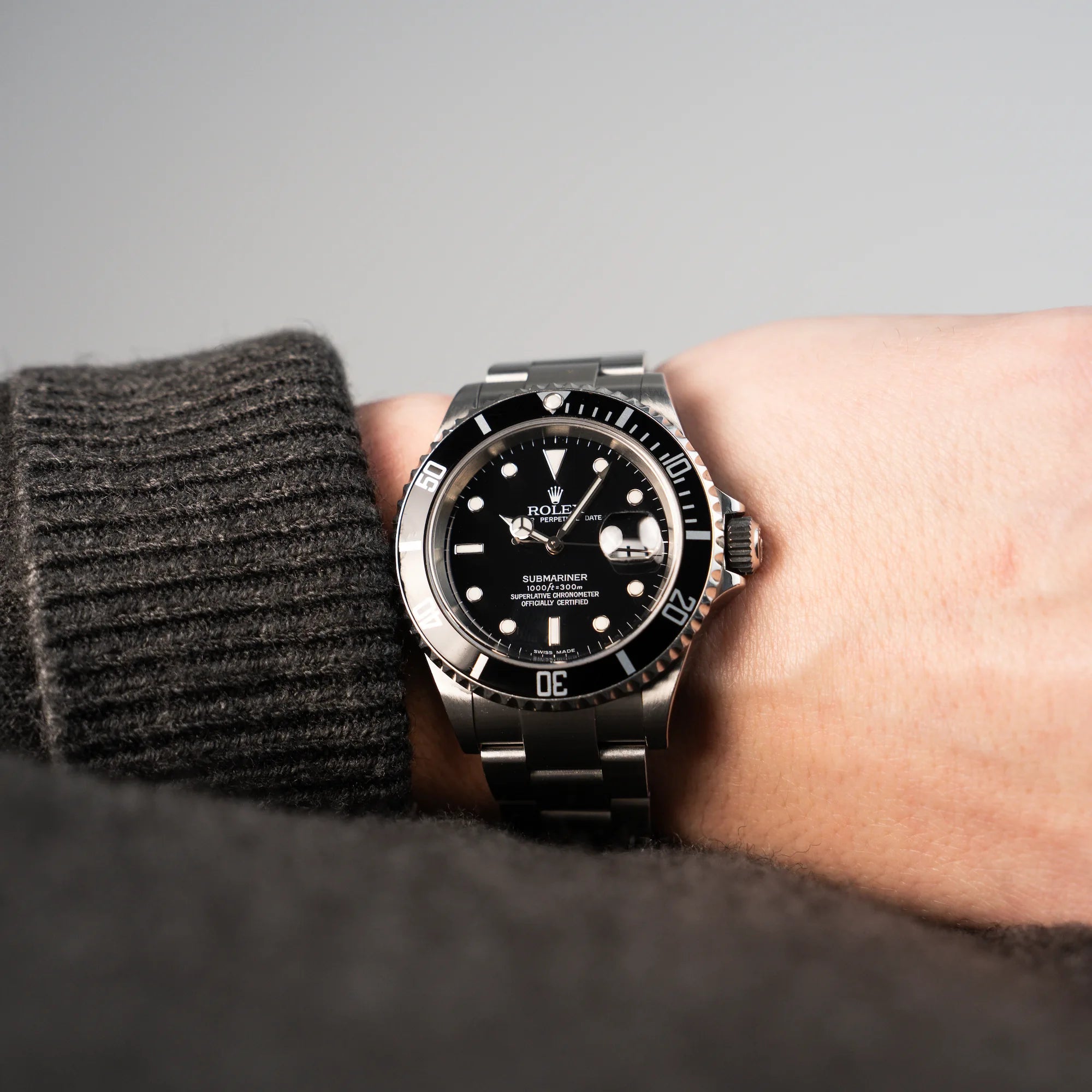 Mann trägt die Rolex Submariner Date in Schwarz mit der Referenz 16610T für eine Wristshot an der Hand