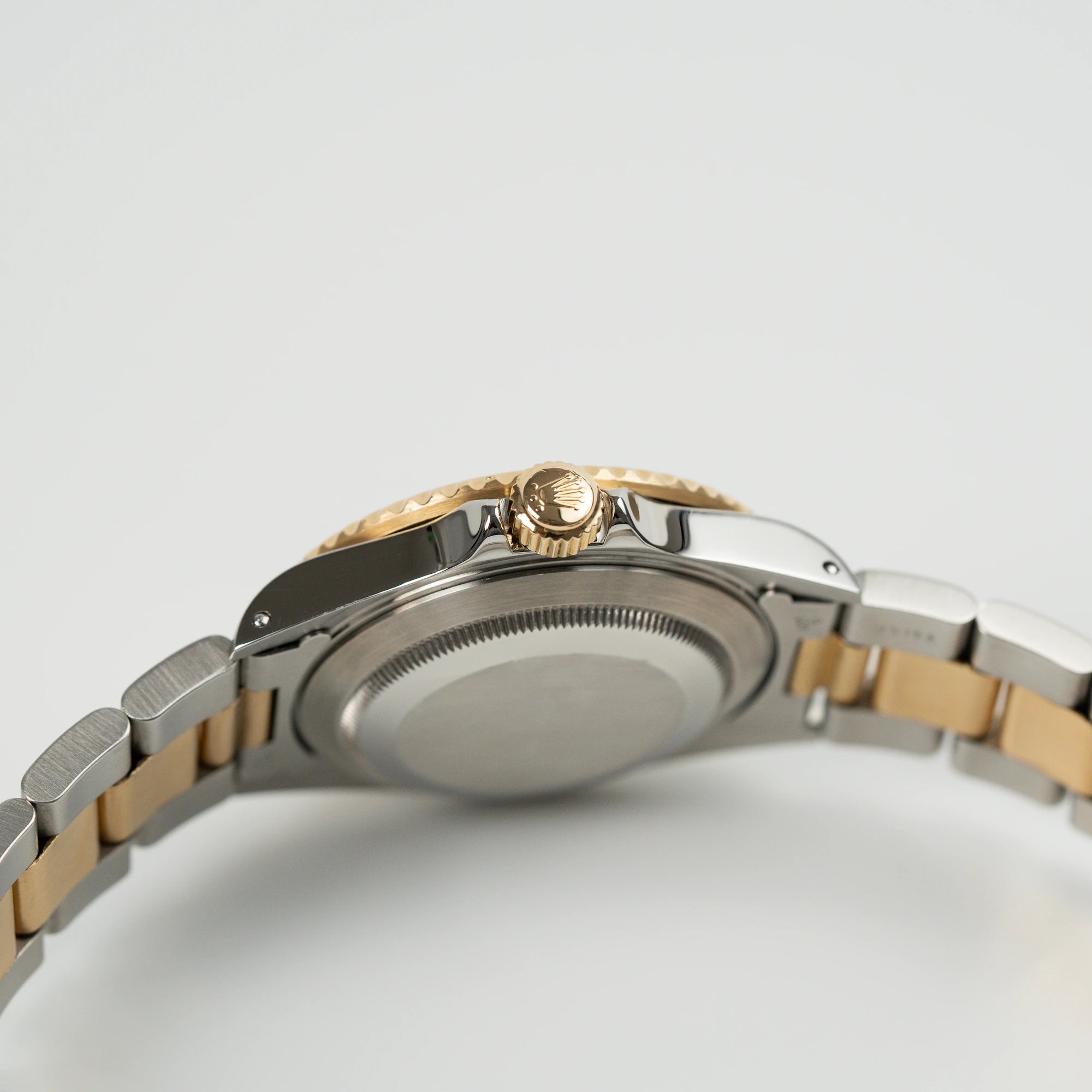 Blick auf das seitliche Gehäuse mit der goldenen Krone der Rolex Submariner Date "Bluesy" in Stahl-Gold mit blauem Zifferblatt und Lünette