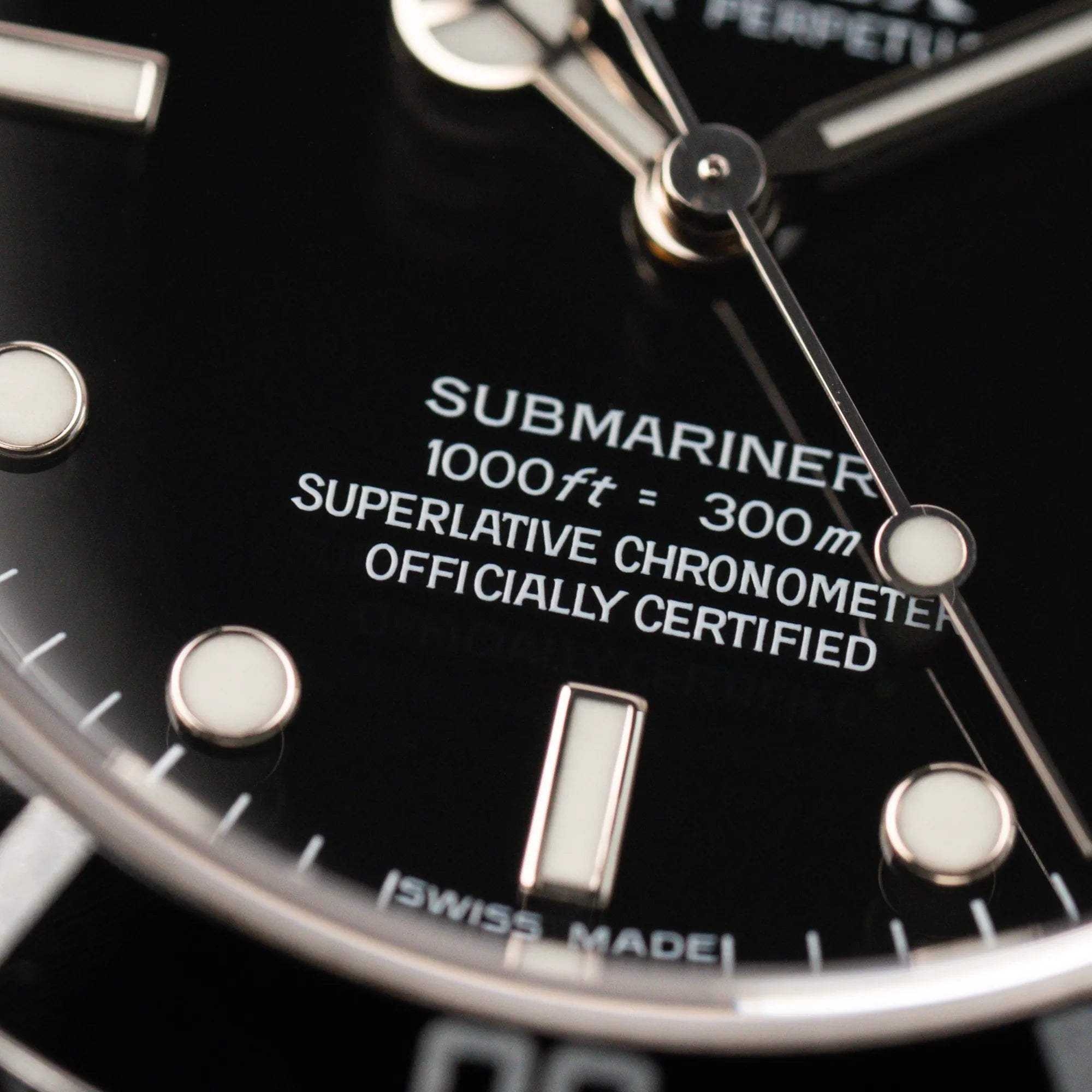 Makroaufnahme des "Submariner" Schriftzugs auf dem schwarzen Zifferblatt der Rolex Submariner NoDate 14060M