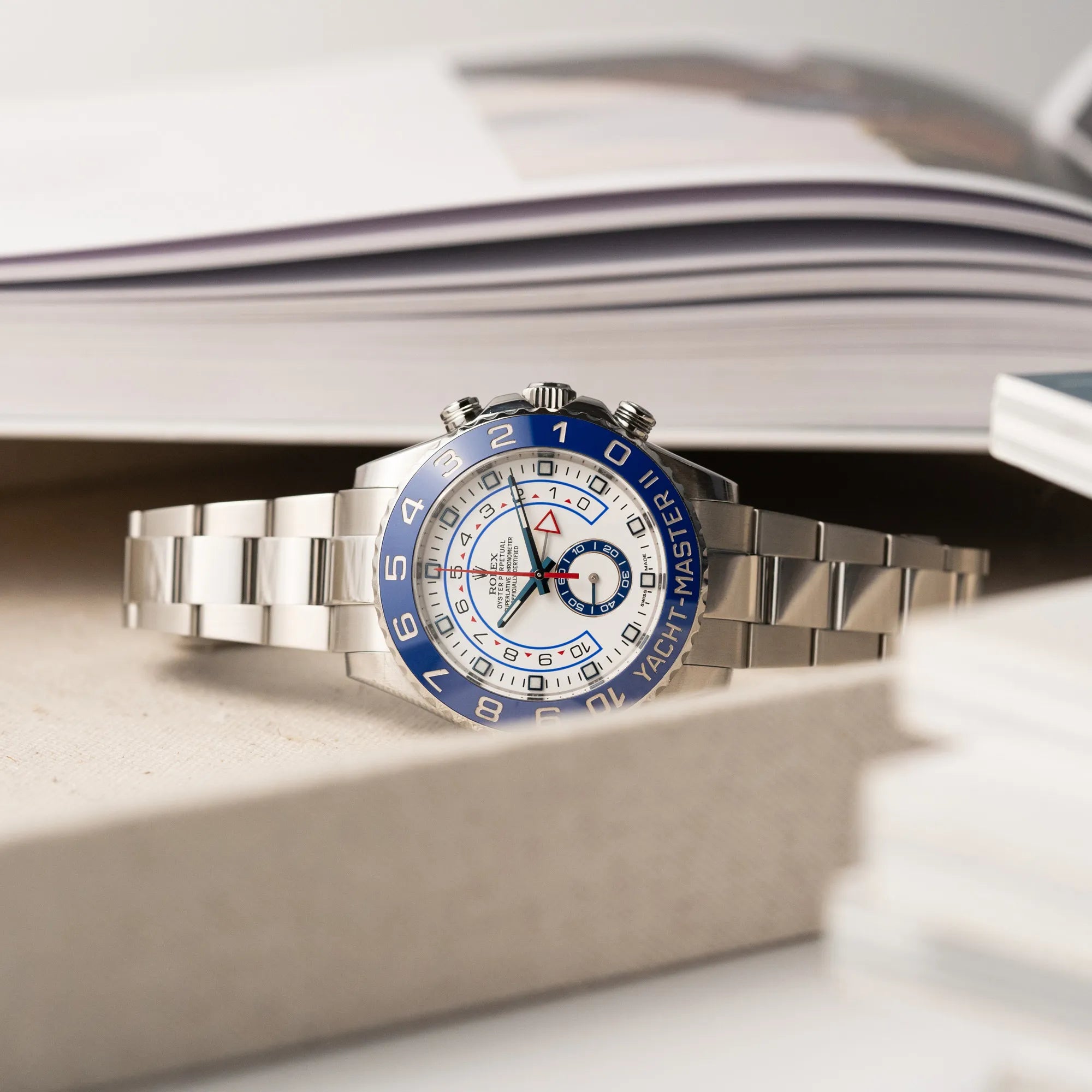 Produktfoto der Rolex Yacht-Master 2 mit weißem Zifferblatt und blauer Lynette auf einem Juwelierstablet