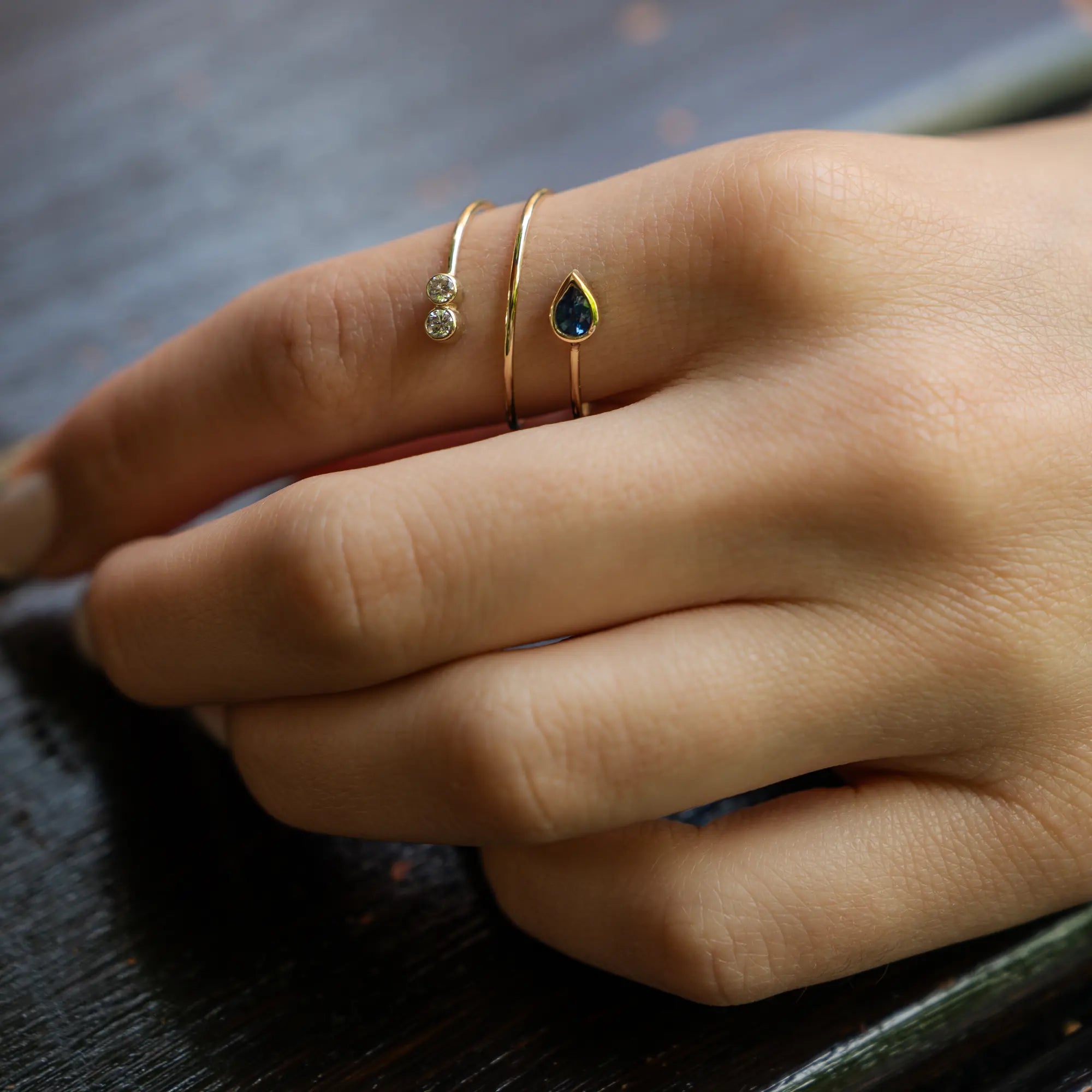 Frau trägt den gelbgoldenen Twisted Saphir Brillant Ring aus der Schmuckatelier Lang Collection an Ihrem Zeigefinger