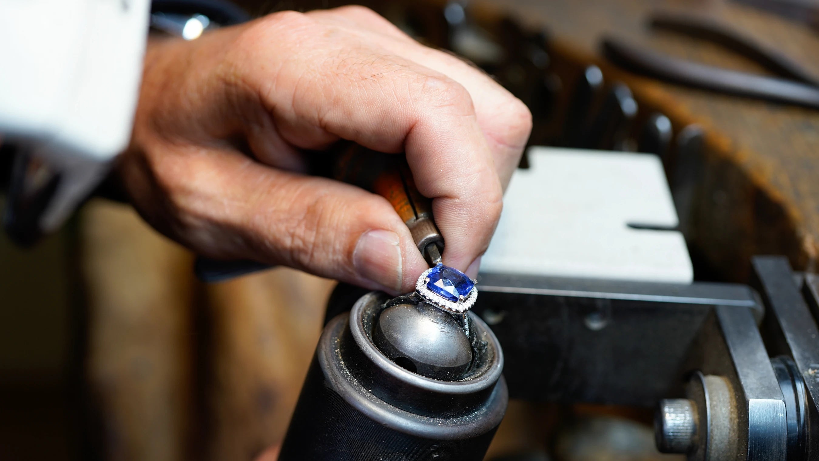 Goldschmied fasst Tansanit per Hand in einen Weißgoldring
