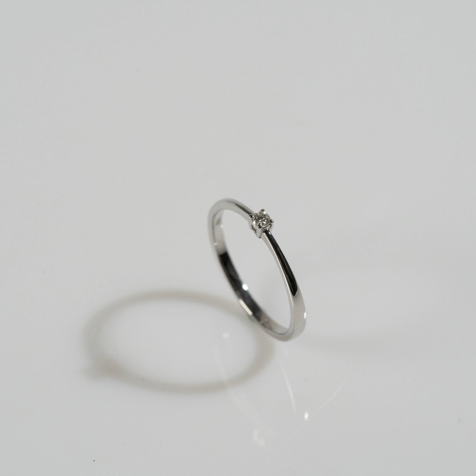Produktfotografie mit einem Blickwinkel von schräg oben des Weißgold-Verlobungsrings "Forever" aus der Schmuckatelier Lang Collection mit einem in einer 4er Kappe gefassten Diamanten mit einem Gewicht von 0.1 Carat