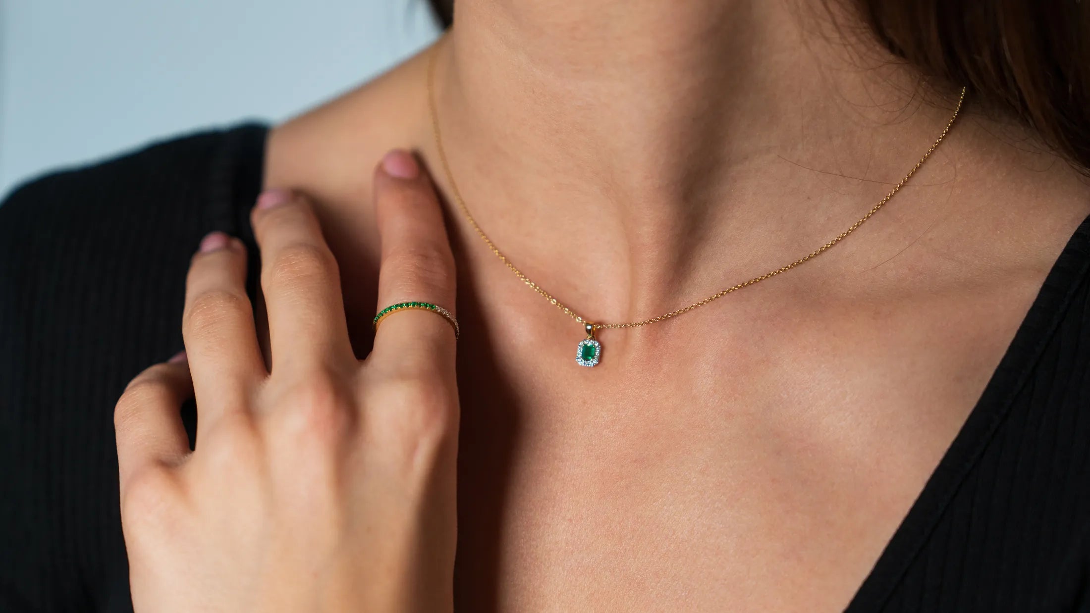 Frau trägt ein Schmuckset aus der Schmuckatelier Lang Collection - das Gelbgold-Smaragd-Collier und den passenden Gelbgold-Smaragd-Brilliant-Ring