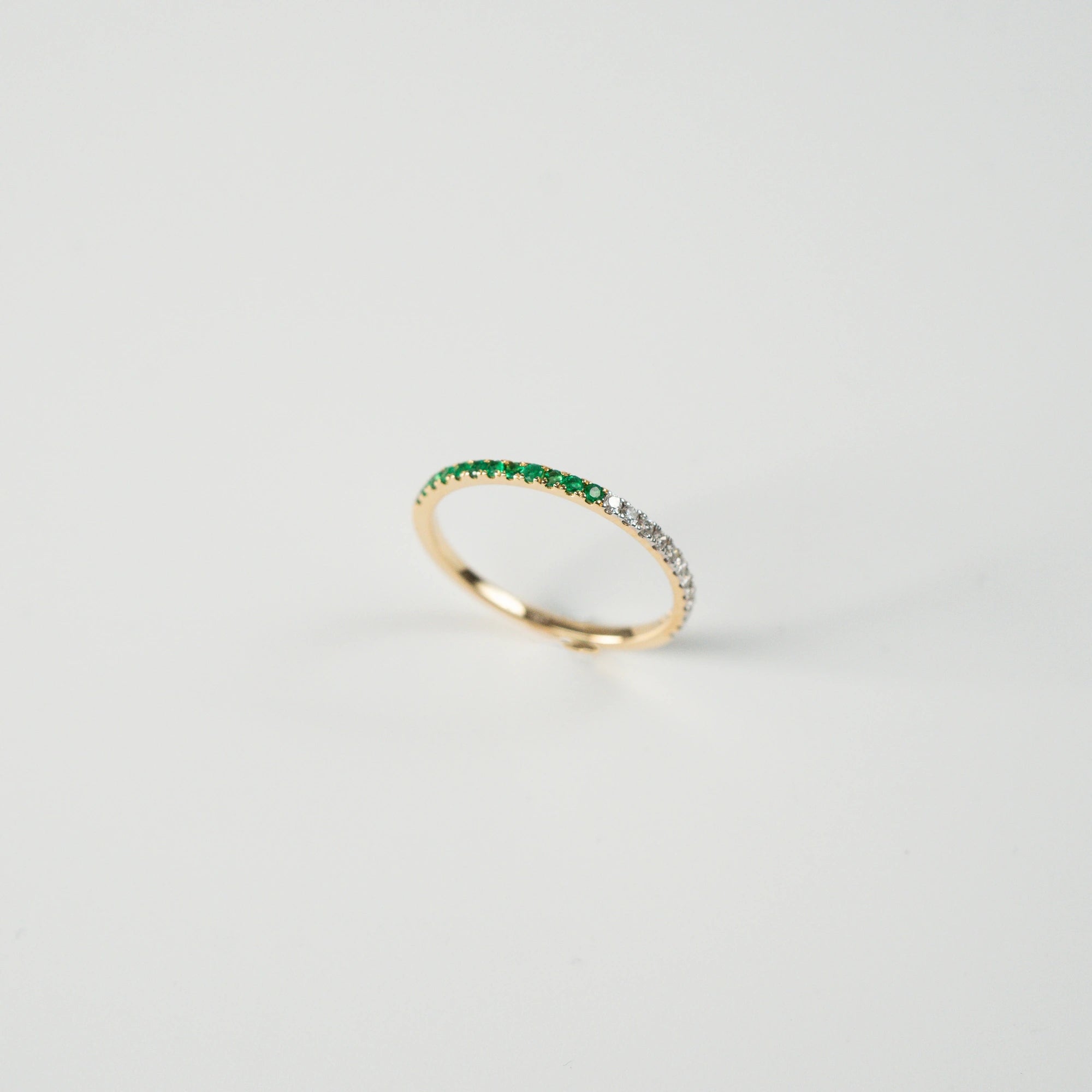 Produktfoto des stehenden Memoire Rings aus der Schmuckatelier Lang Collection, der halb mit Smaragden und halb mit Diamanten besetzt ist