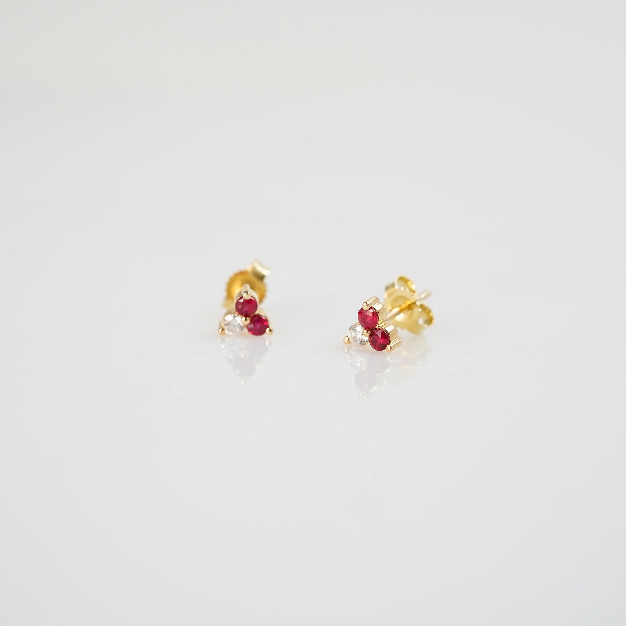 Produktfoto der gelbgoldenen Rubin Ohrstecker aus der Schmuckatelier Lang Collection mit zwei Rubinen und einem Brillanten