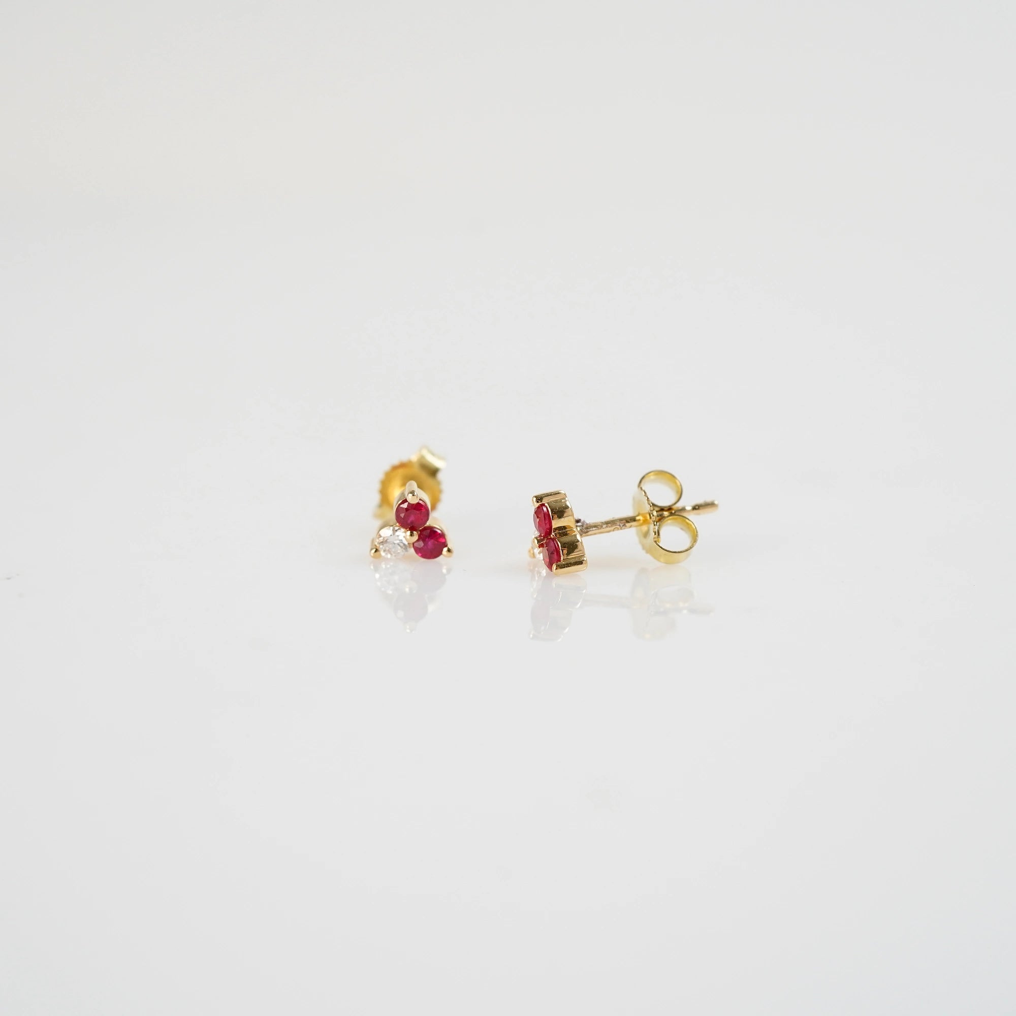 Produktfoto der gelbgoldenen Rubin Ohrstecker aus der Schmuckatelier Lang Collection mit zwei Rubinen und einem Brillanten - der linke Ohrstecker zeigt dabei die frontale Ansicht, der rechte Ohrstecker die seitliche Ansicht