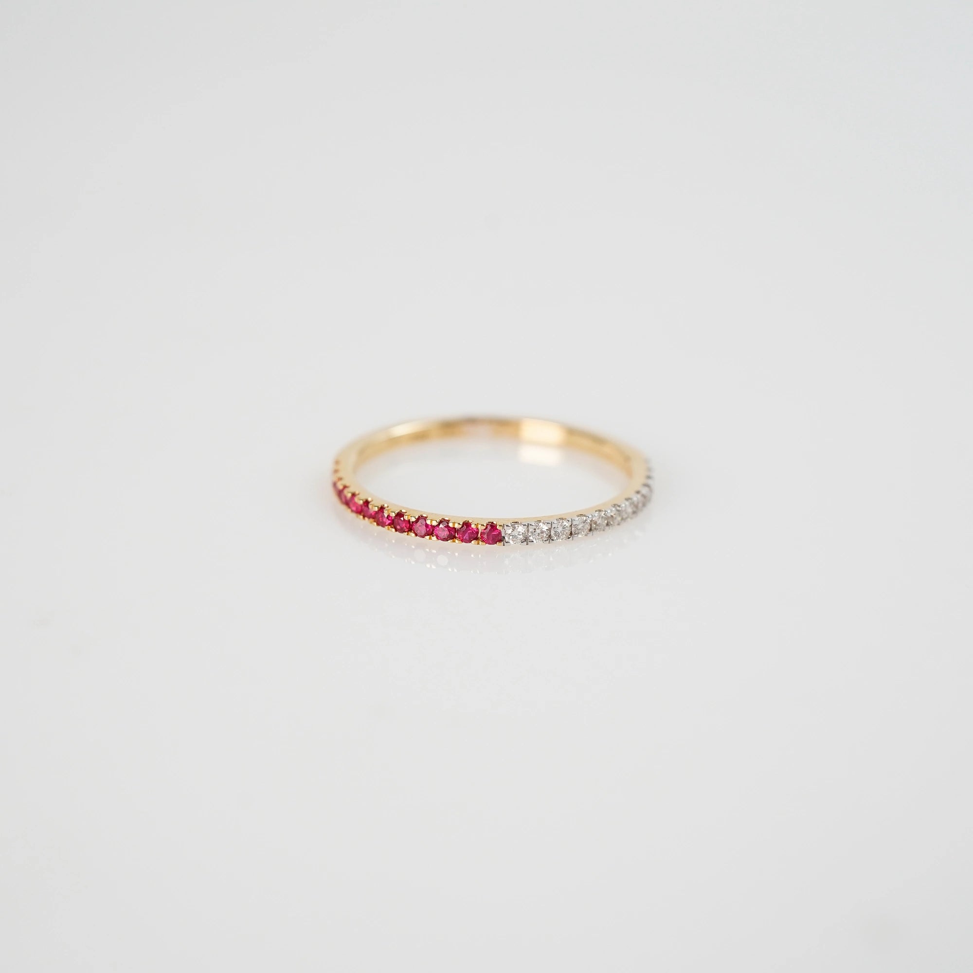 Produktfoto des liegenden Memoire Rings aus der Schmuckatelier Lang Collection, der halb mit Rubinen und halb mit Diamanten besetzt ist