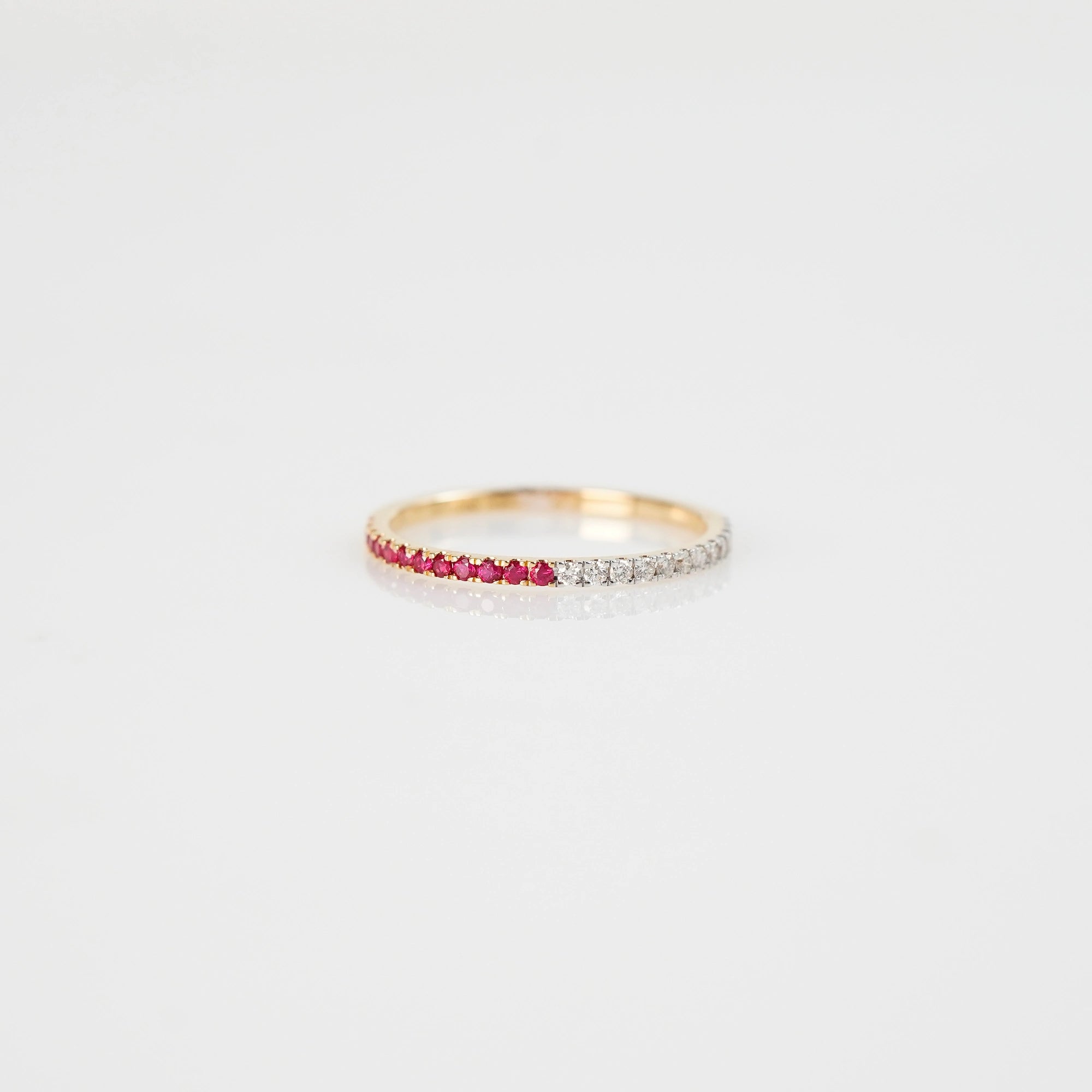 Produktfoto des liegenden Memoire Rings aus der Schmuckatelier Lang Collection, der halb mit Rubinen und halb mit Diamanten besetzt ist