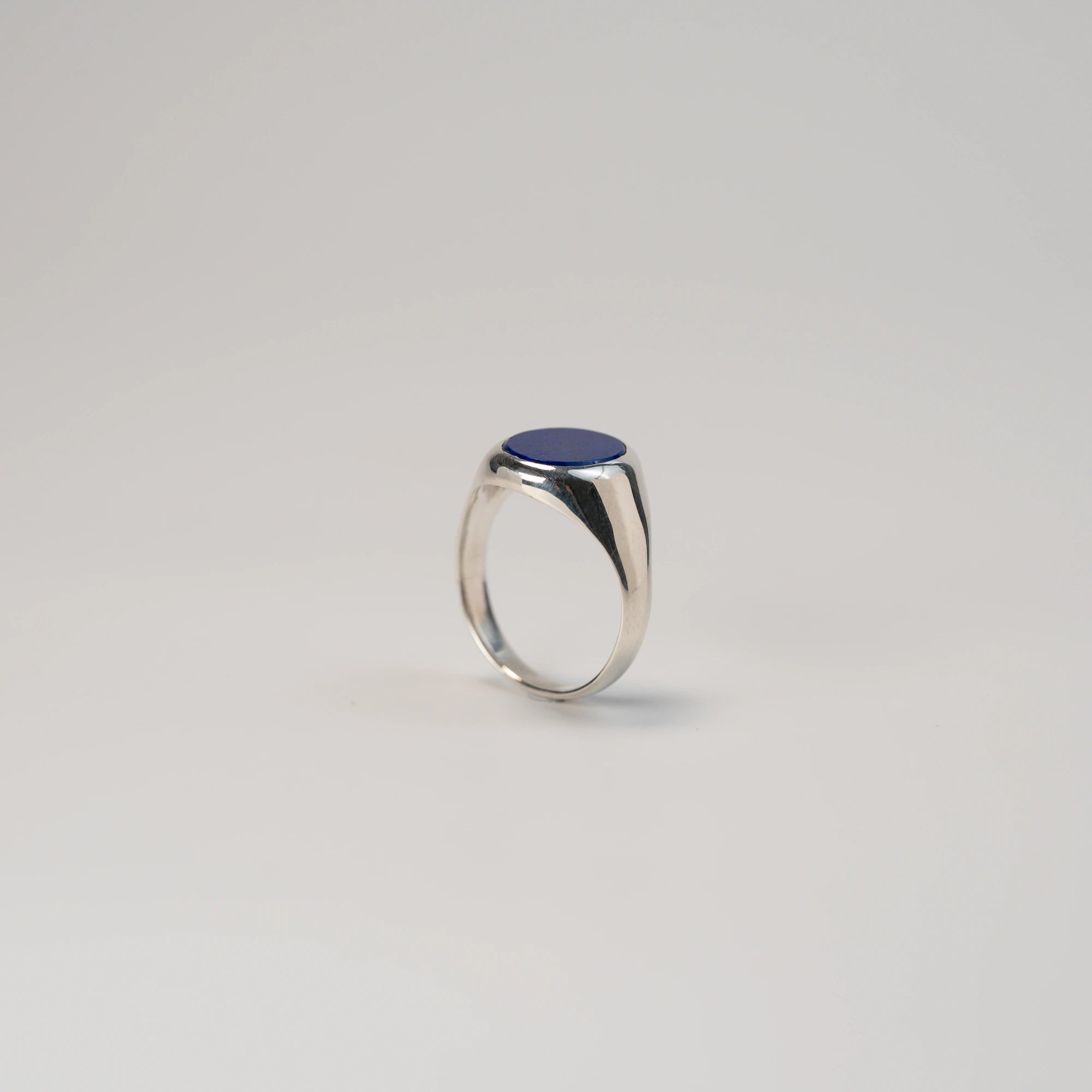 Seitliche Ansicht des stehenden, handgefertigten Siegelrings aus 925er Silber mit einem eingefassten, ovalen Lapis Lazuli Edelstein