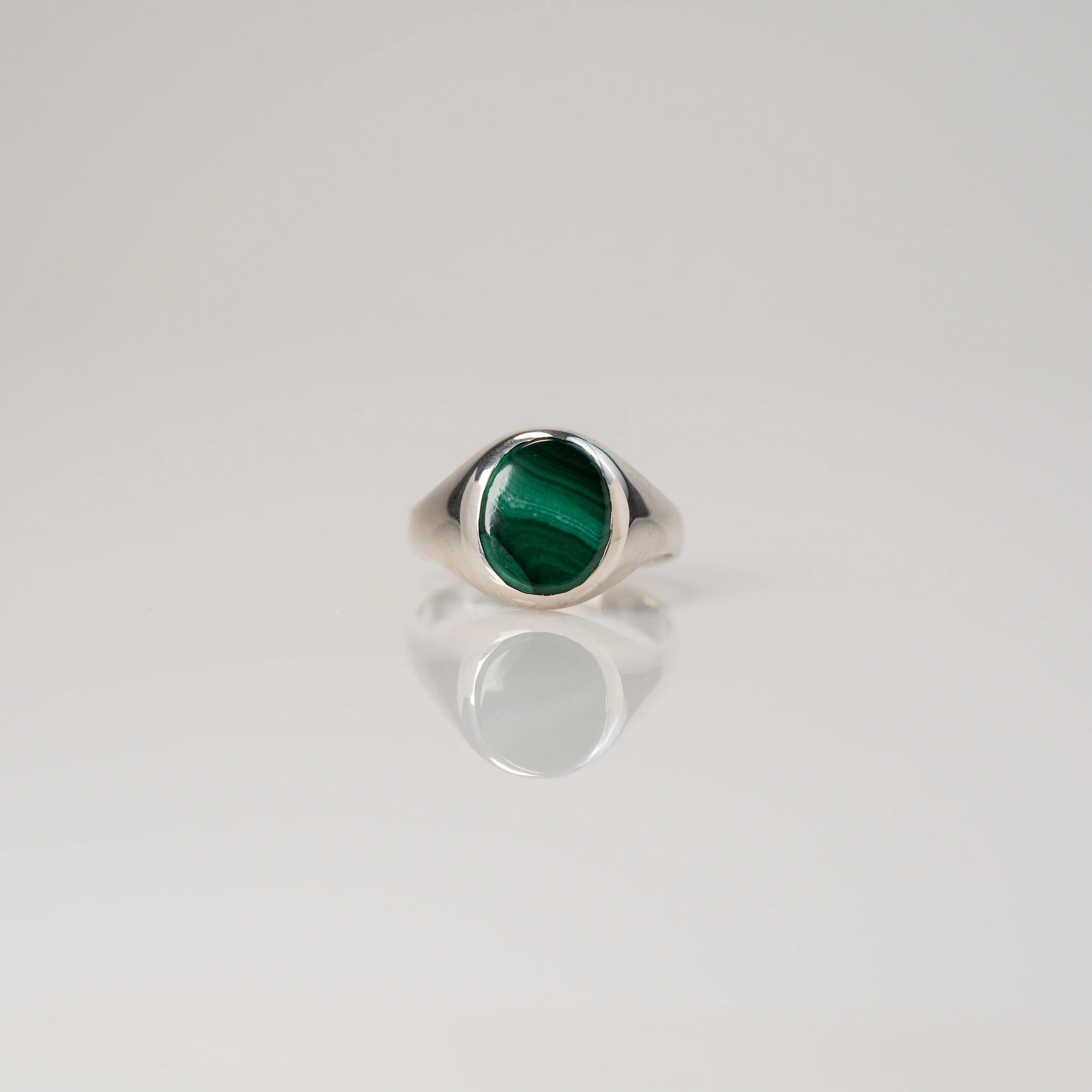 Frontale Ansicht des handgefertigten Siegelrings aus 925er Silber mit einem eingefassten, ovalen Malachit Edelstein