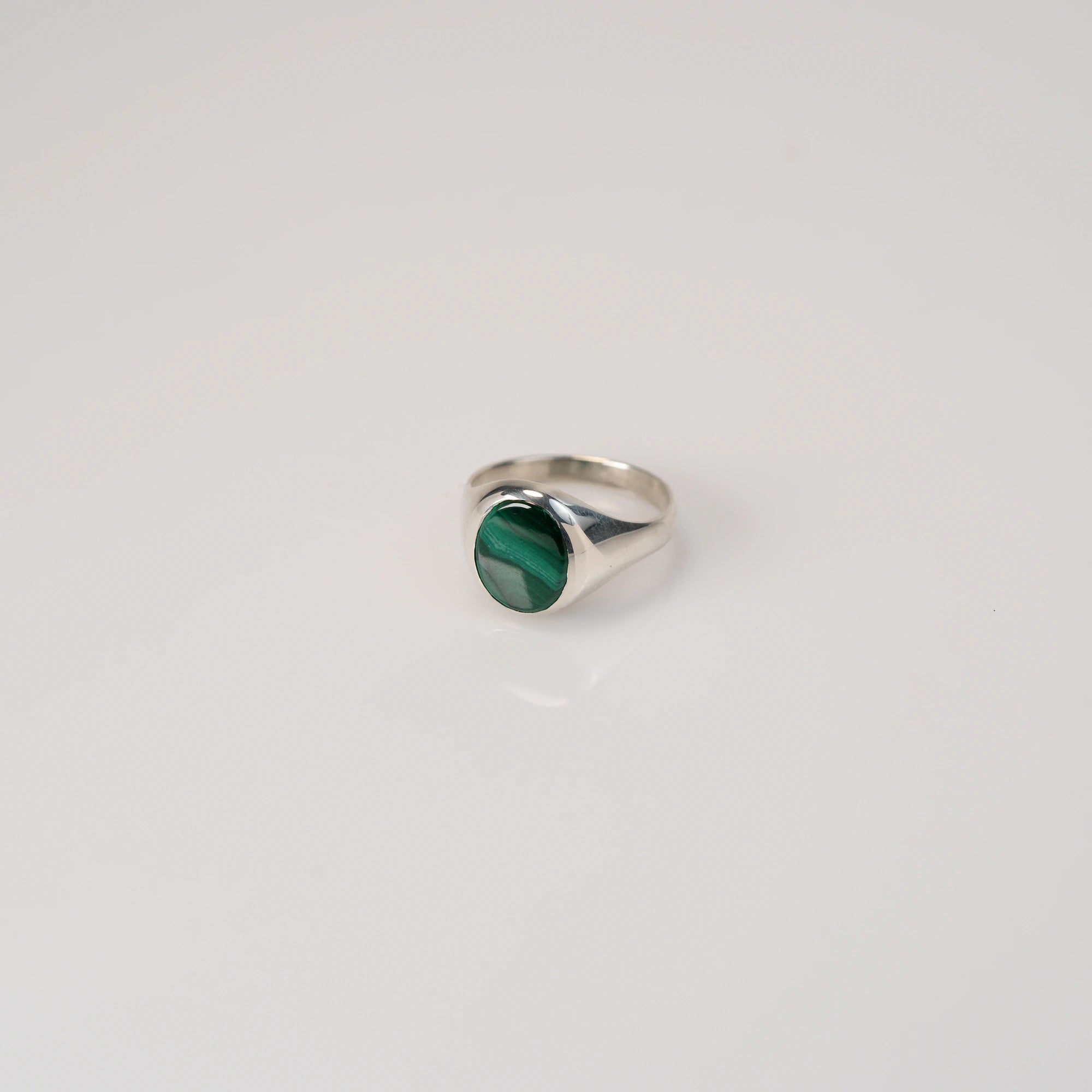 Leicht schräge Ansicht des handgefertigten Siegelrings aus 925er Silber mit einem eingefassten, ovalen Malachit Edelstein