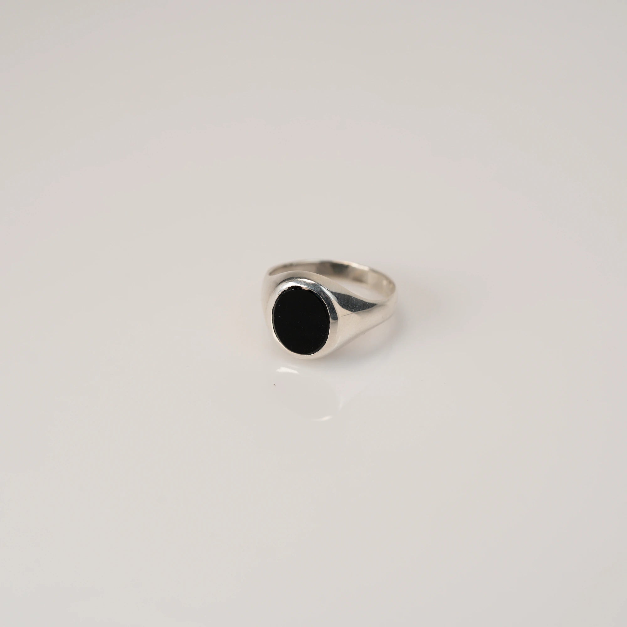Leicht schräge Ansicht des handgefertigten Siegelrings aus 925er Silber mit einem eingefassten, ovalen Onyx Edelstein