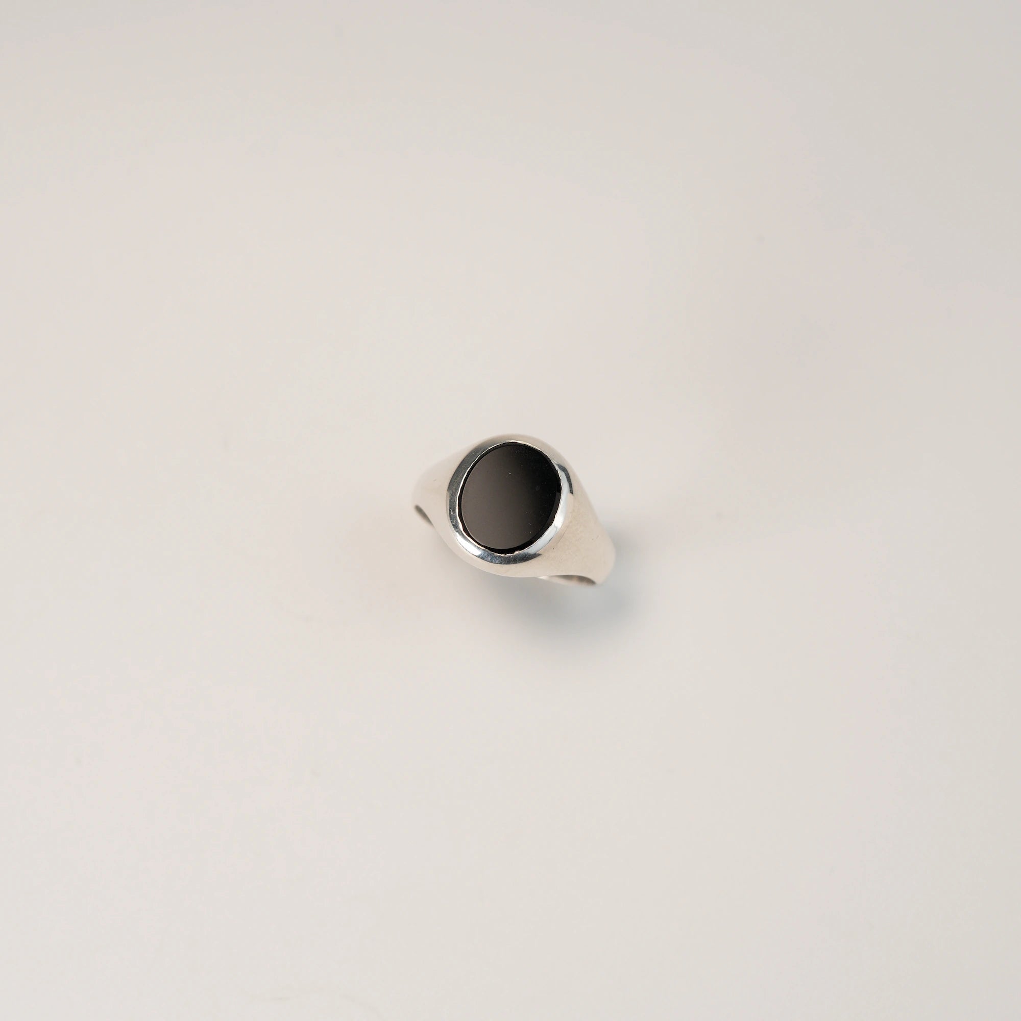 Zentraler Blick von Oben auf den handgefertigten Siegelring aus 925er Silber mit einem eingefassten, ovalen Onyx Edelstein