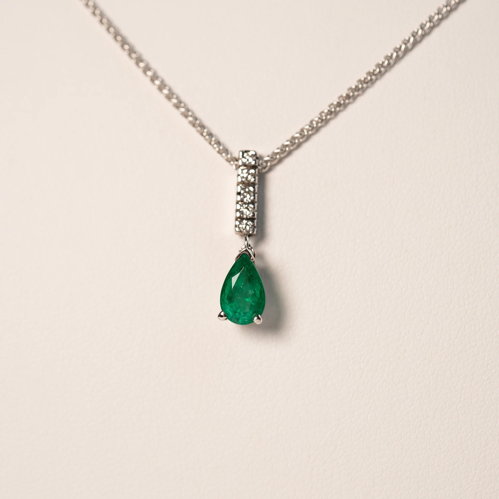 Makroaufnahme des Anhängers, bestehend aus einem Diamant-Steg und einem kräftigen, grünem Smaragd im Tropfenschliff aus der Schmuckatelier Lang Collection