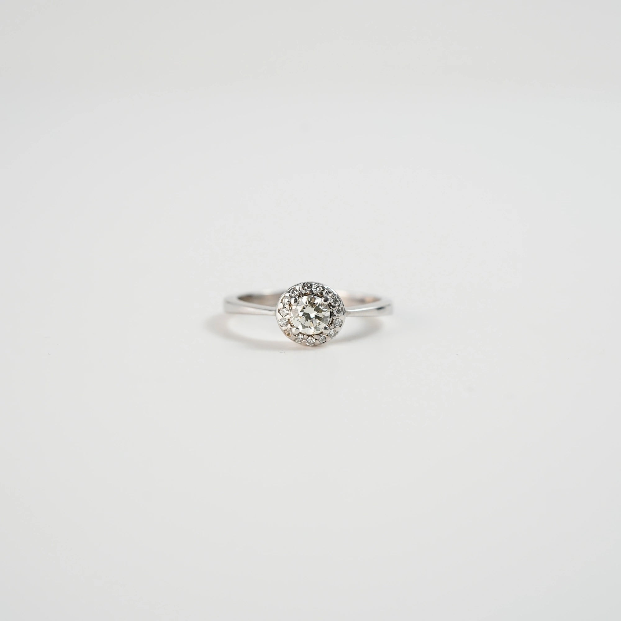 Frontale Ansicht des liegenden Verlobungsrings "Blossom" aus der Schmuckatelier Lang Collection in Weißgold mit einem markantem Detail aus mehreren Diamanten, dass in der Anordnung an eine Blüte erinnert