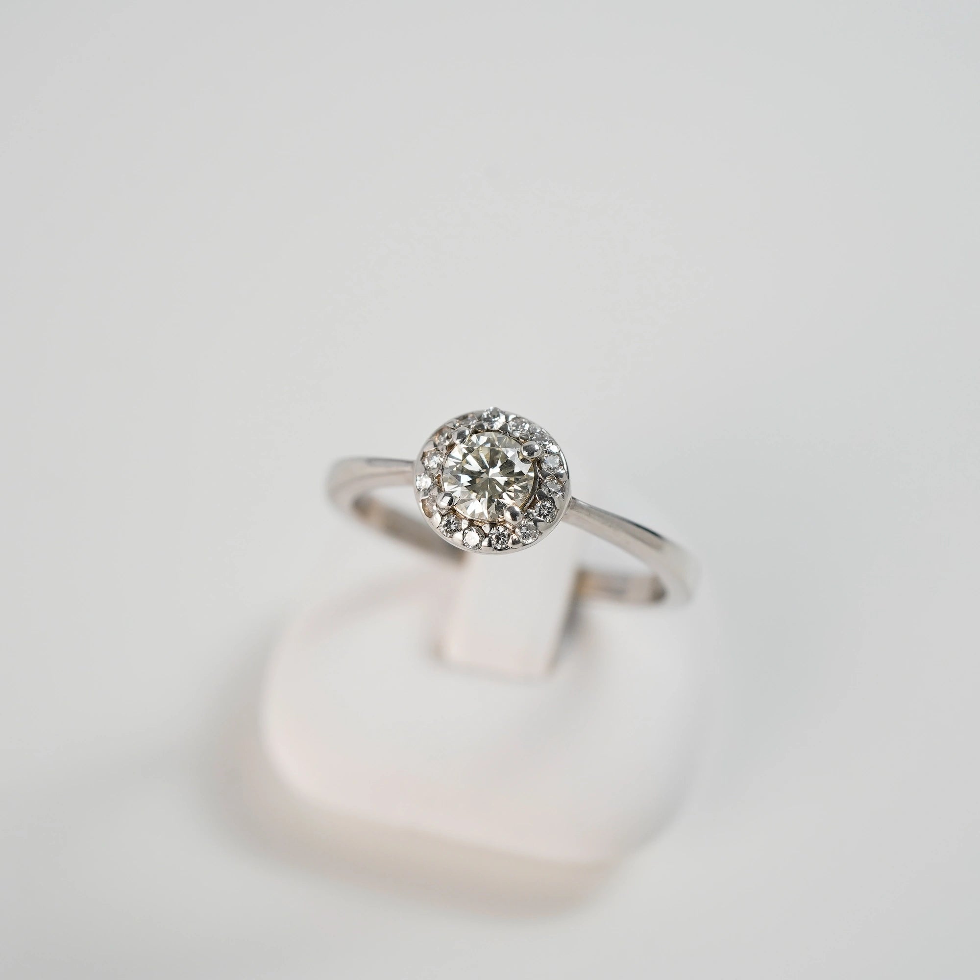 Leicht schräger Blick von Oben auf den Verlobungsring "Blossom" aus der Schmuckatelier Lang Collection in Weißgold mit einem markantem Detail aus mehreren Diamanten, dass in der Anordnung an eine Blüte erinnert