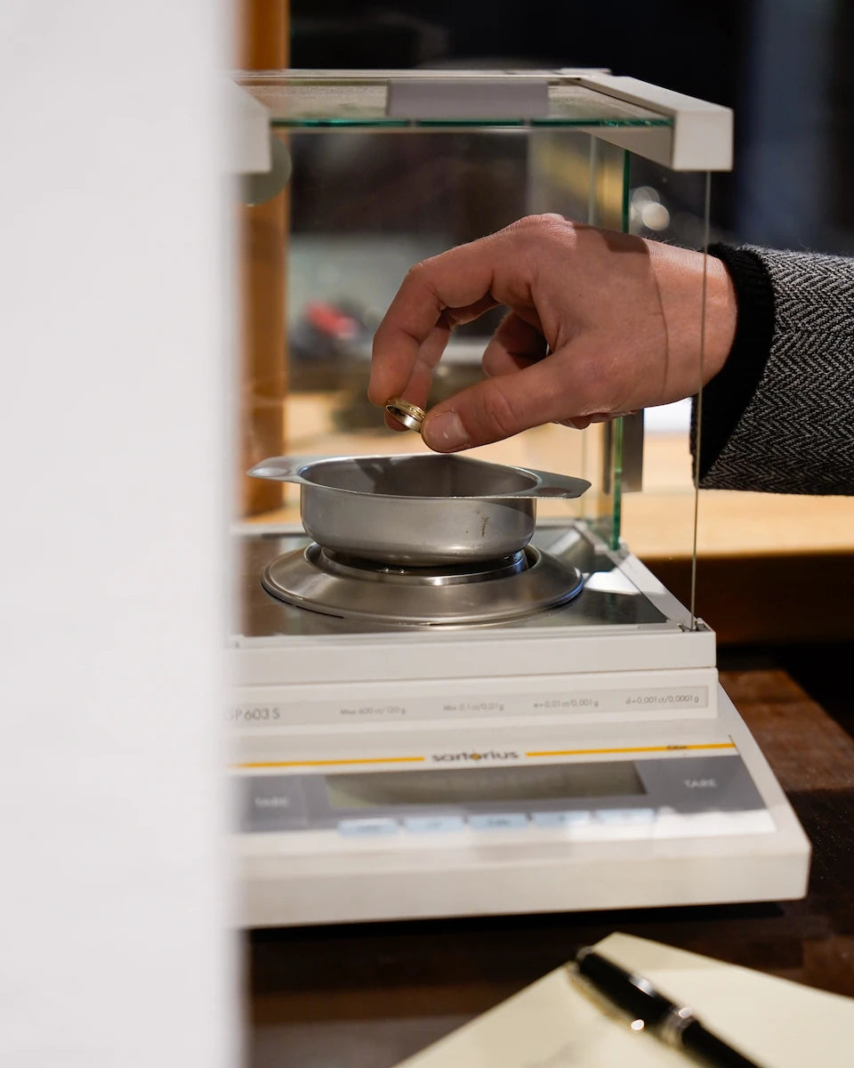 Abwiegen eines Goldrings mit einer Feinwaage für die exakte Gewichtsbestimmung während eines Altgold-Ankaufs bei Schmuckatelier Lang