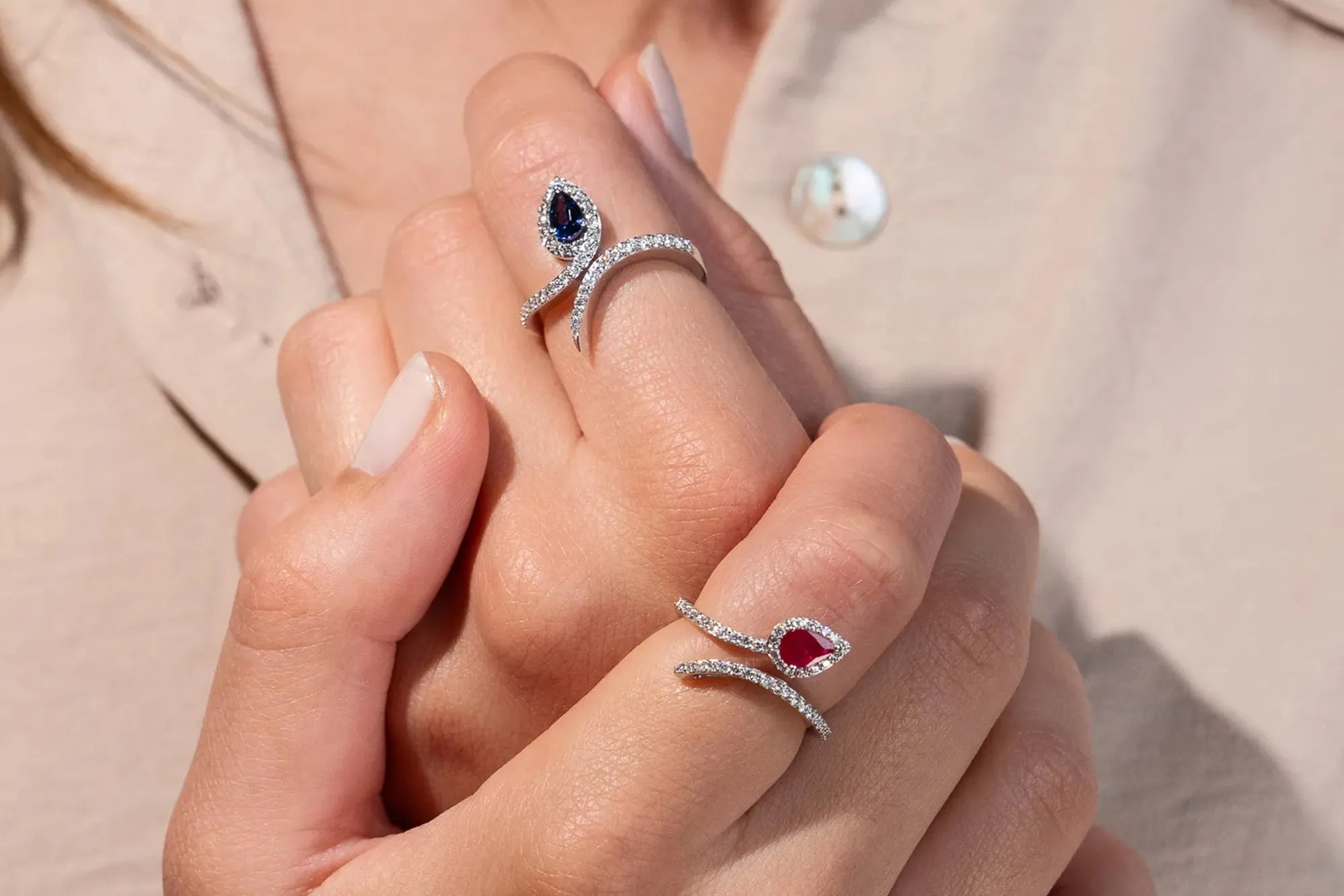 Frau trägt zwei Lunatica Roma Spagna Ringe an Ihren Händen, die mit Diamanten verziert sind sind und entweder einen Saphir oder einen Rubin als Hauptstein besitzen