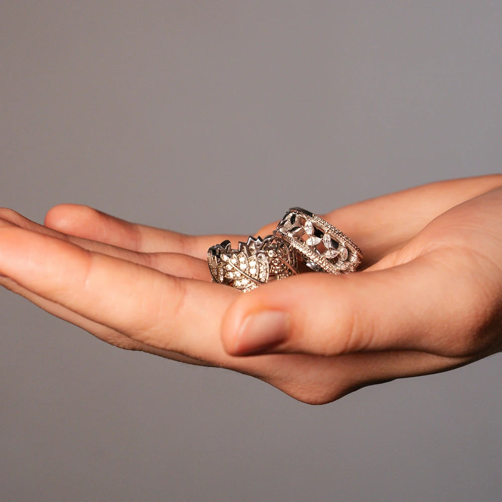 Frau hält zwei Ringe in Ihrer Handfläche und präsentiert die silbernen Modeschmuck-Ringe mit Zirkonia-Besatz