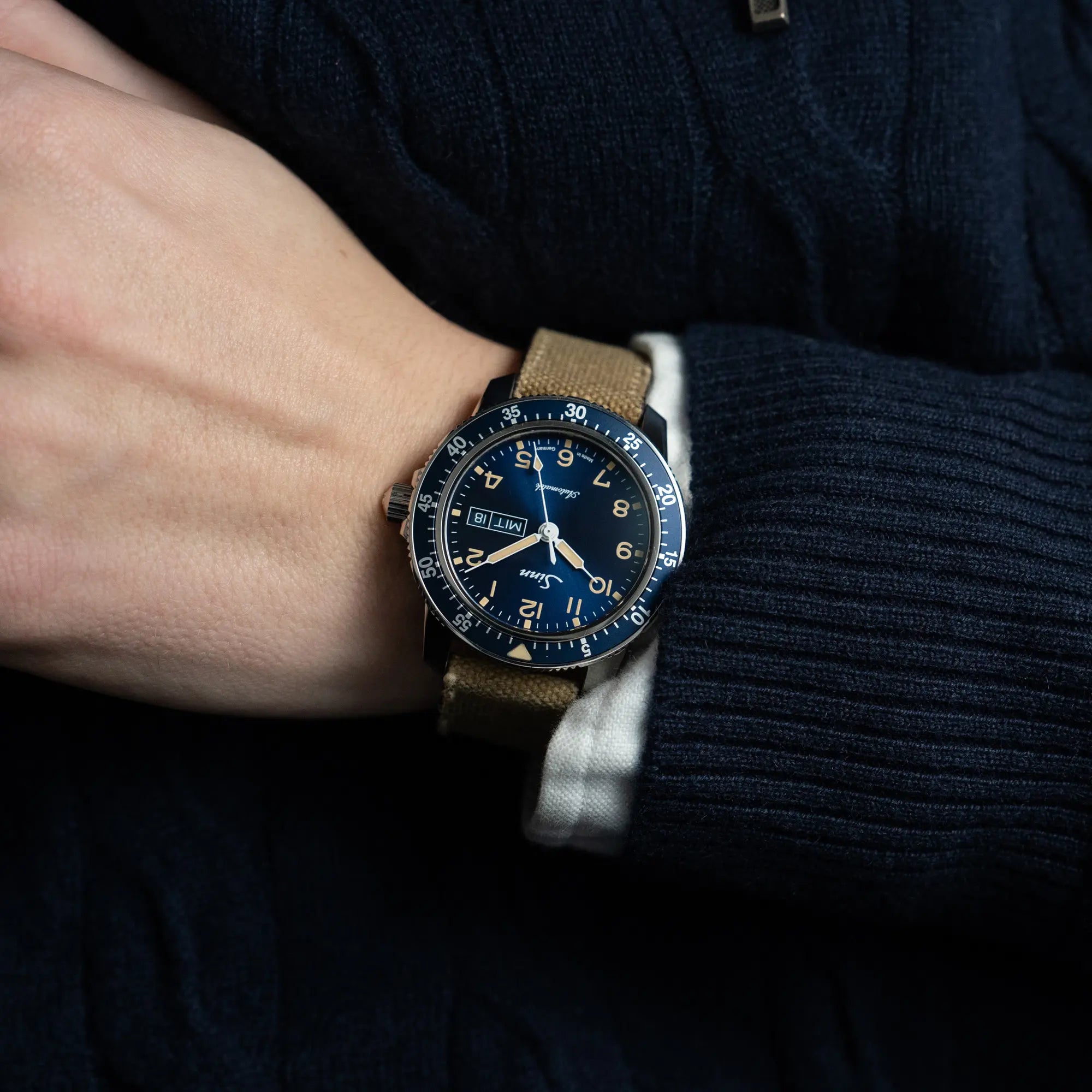 Mann trägt die Taucheruhr Sinn Automatik SA in Blau mit beigen Akzenten am Textilband an seinem Handgelenk