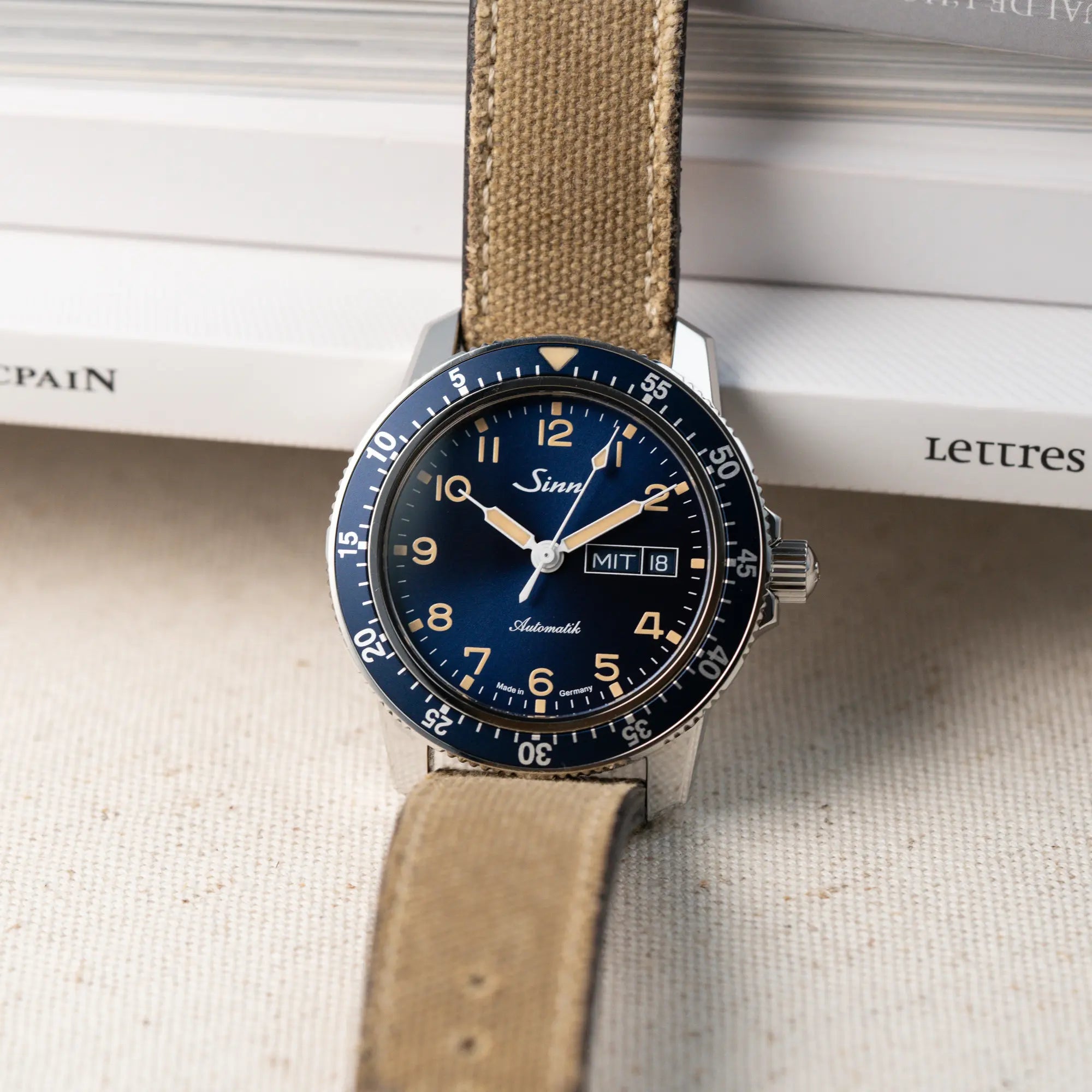 Produktfotografie der Taucheruhr Sinn Automatik SA in Blau mit beigen Akzenten am Textilband