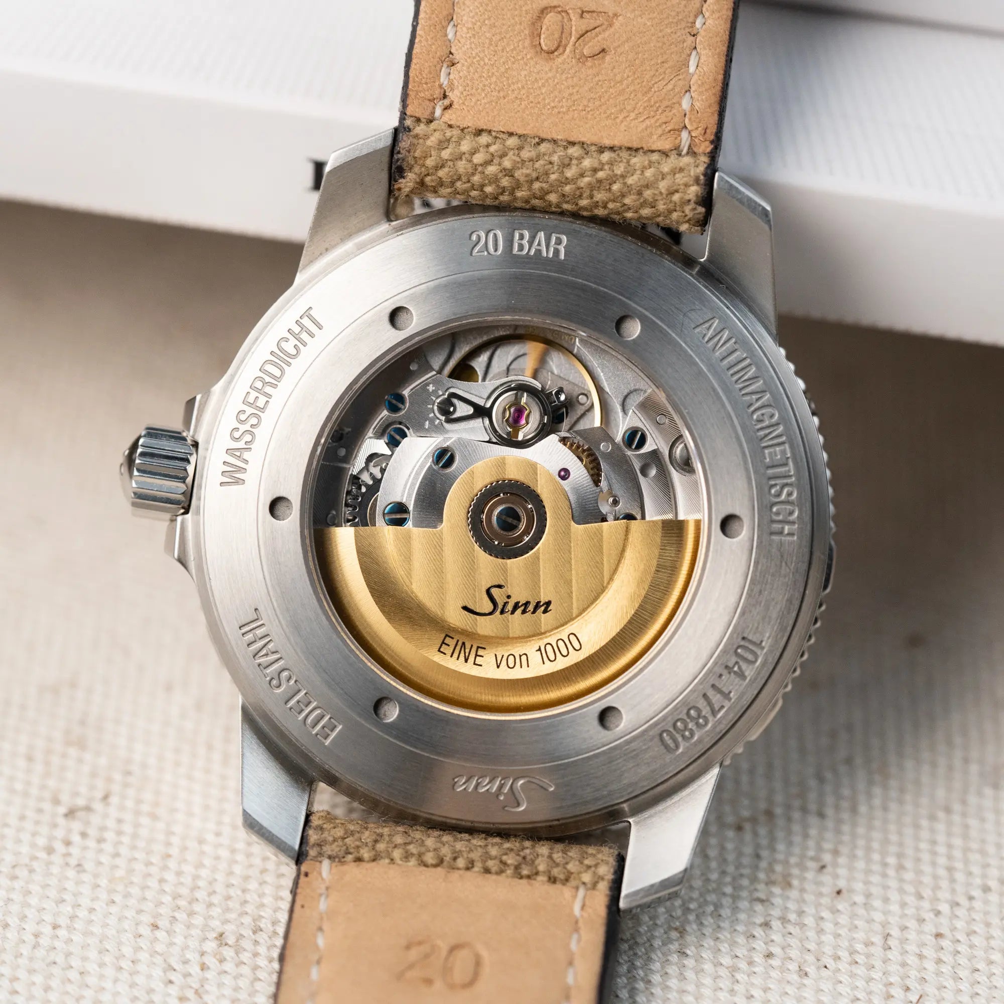 Detailaufnahme des Glasbodens der Taucheruhr Sinn Automatik SA in Blau mit beigen Akzenten am Textilband