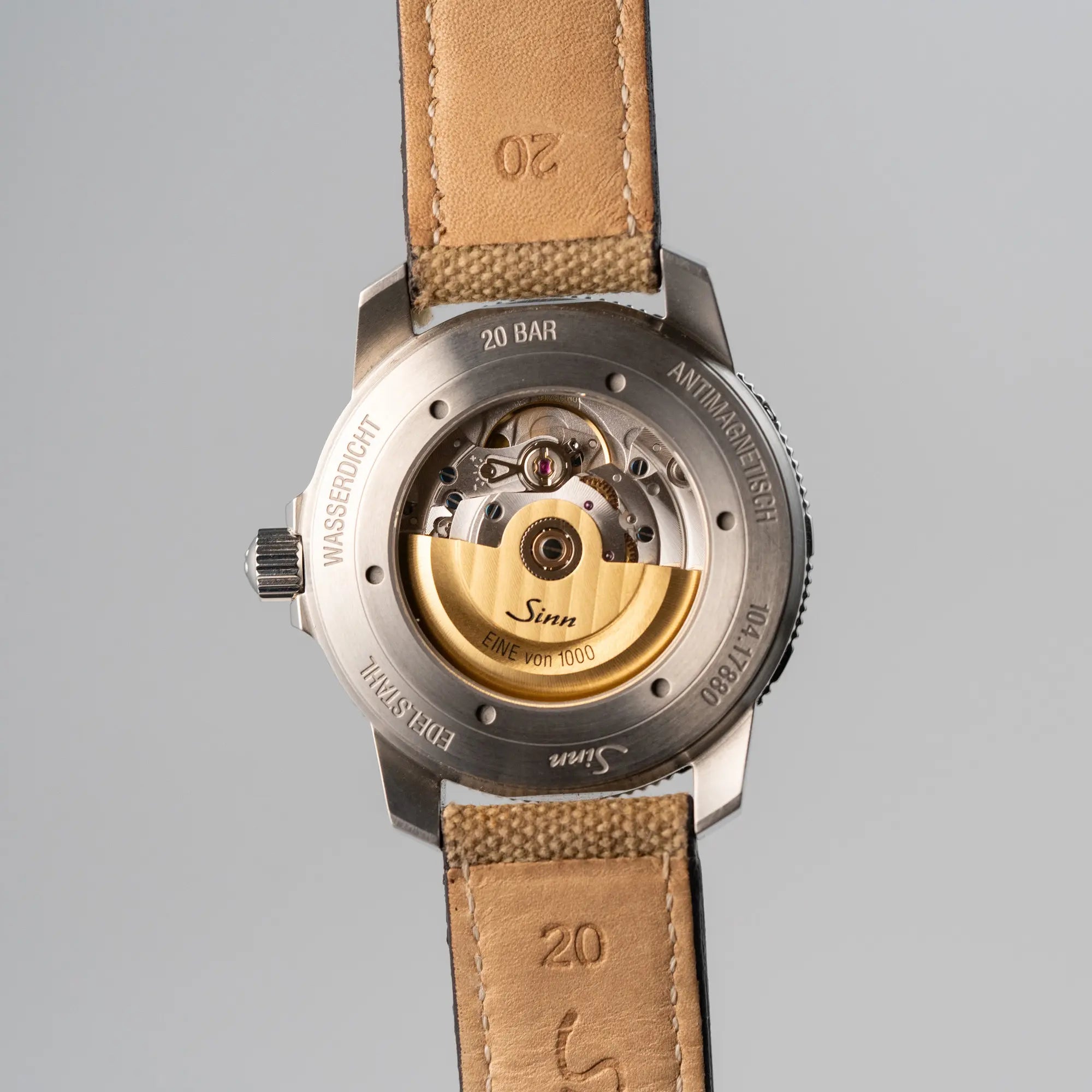 Produktfotografie der Taucheruhr Sinn Automatik SA in Blau mit beigen Akzenten am Textilband mit Fokus auf dem gläsernen Gehäuseboden