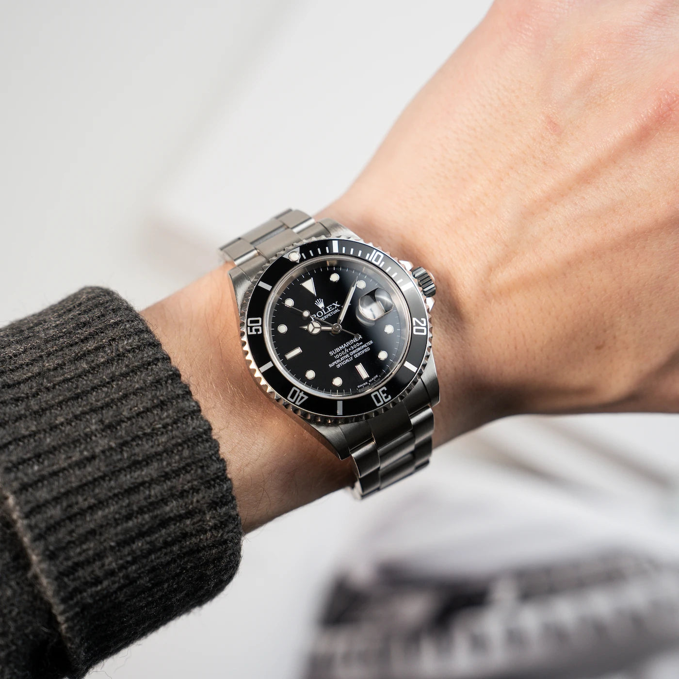 Blick auf eine Rolex Submariner mit schwarzem Zifferblatt und schwarzer Lünette am Handgelenk