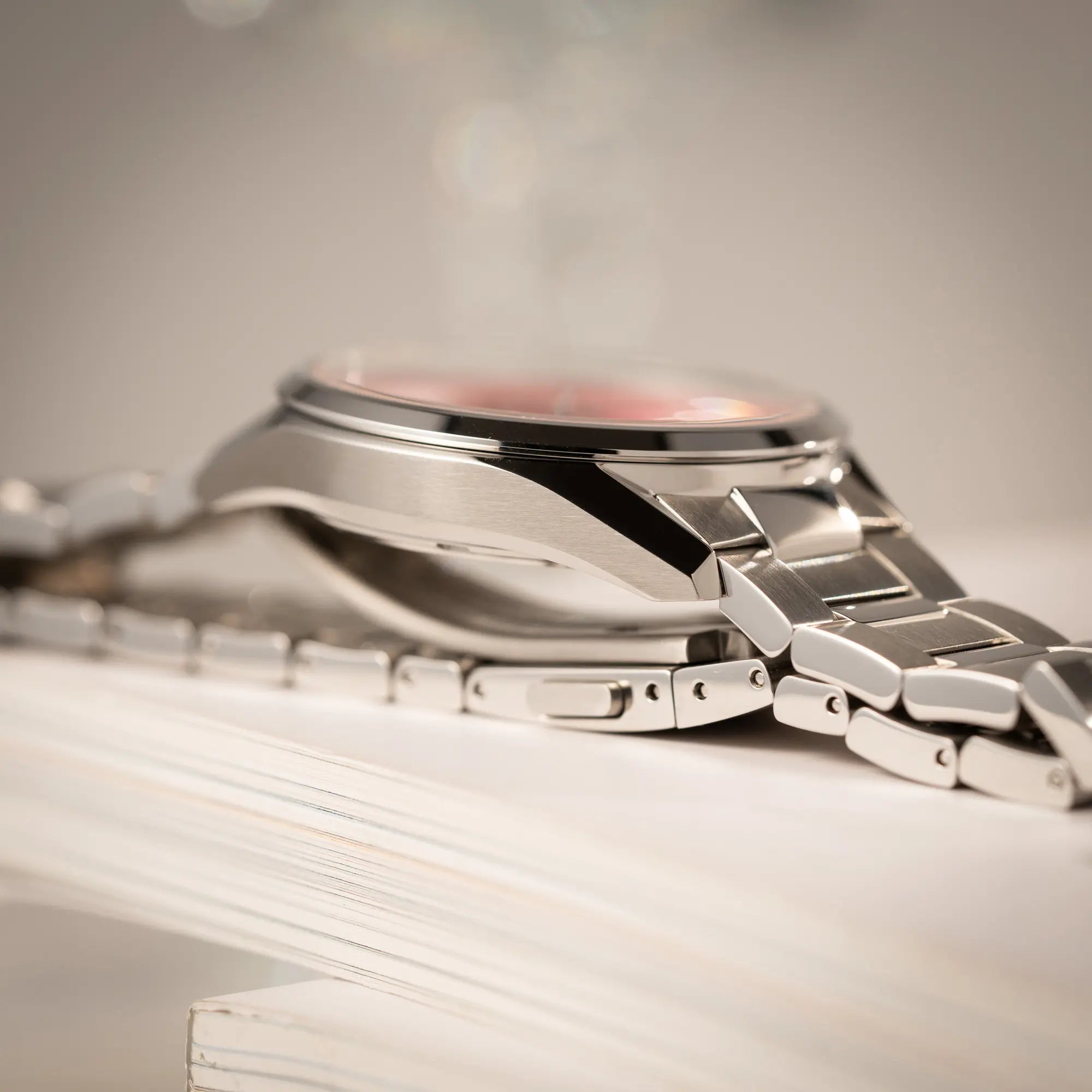 Produktfotografie der Tag Heuer Carrera Date Lady mit einem 36mm-Gehäuse und einem markanten pinken Zifferblatt mit Sonnenschliff-Finish zeigt den Bandanstoß