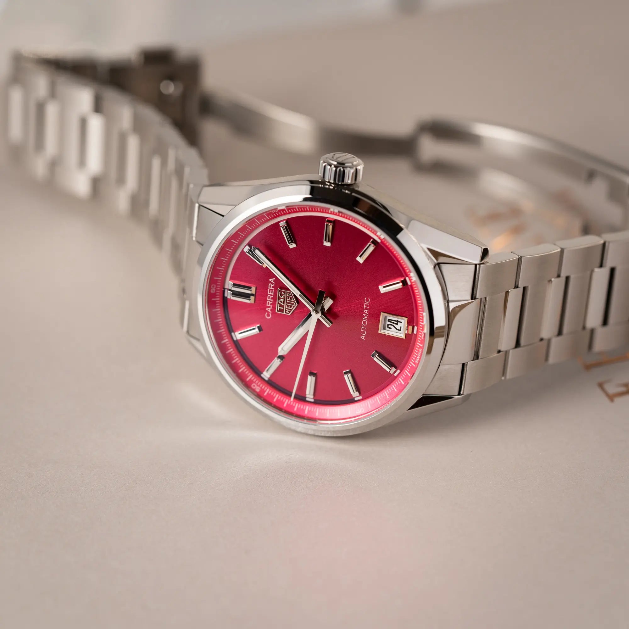 Nahe Produktfotografie der Tag Heuer Carrera Date Lady mit einem 36mm-Gehäuse und einem markanten pinken Zifferblatt mit Sonnenschliff-Finish