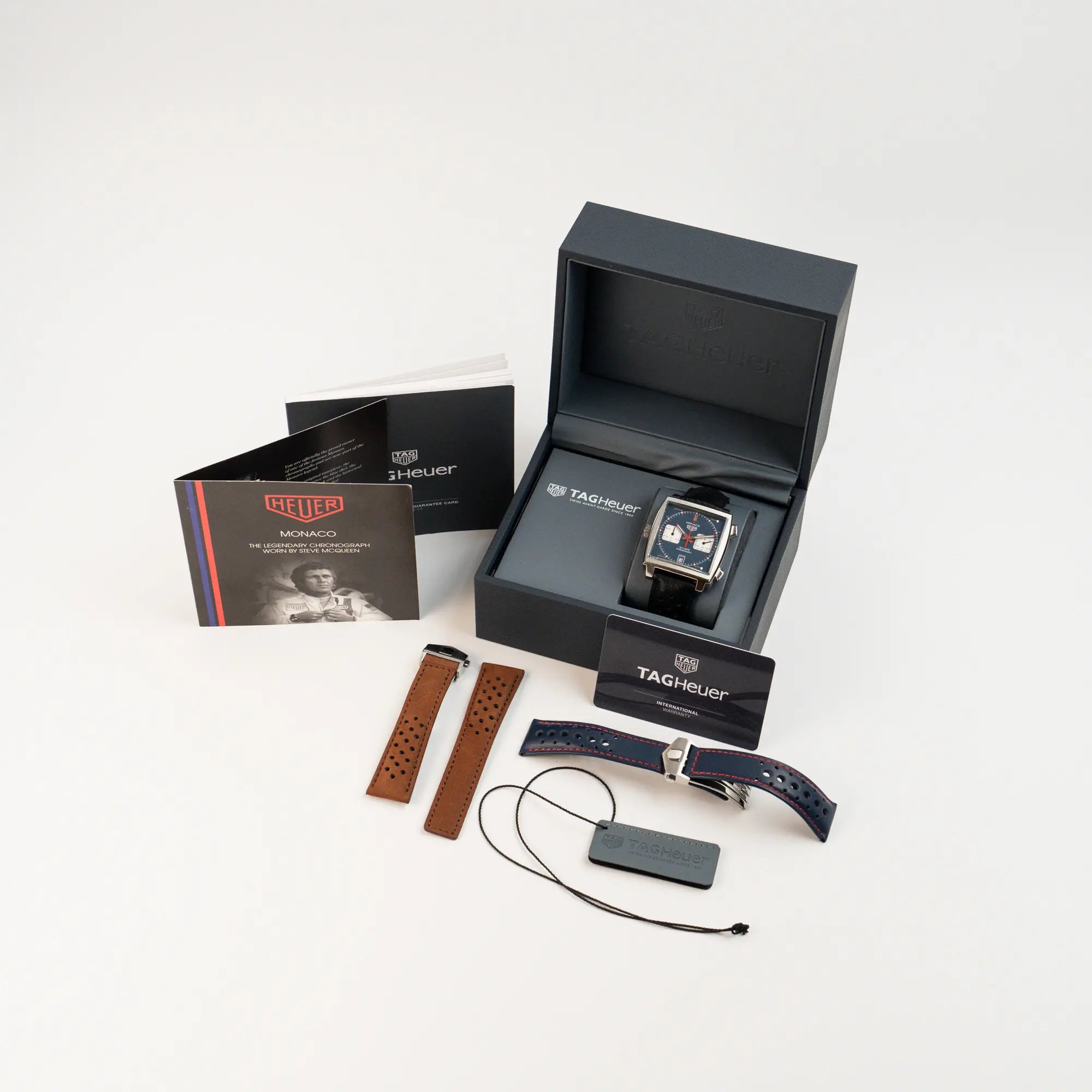 Tag Heuer Monaco Calibre 11 Chronographen CAW211P mit dem klassischen blauen Zifferblatt und roten Details auf Ziegern und Indizes zusammen mit dem Lieferumfang