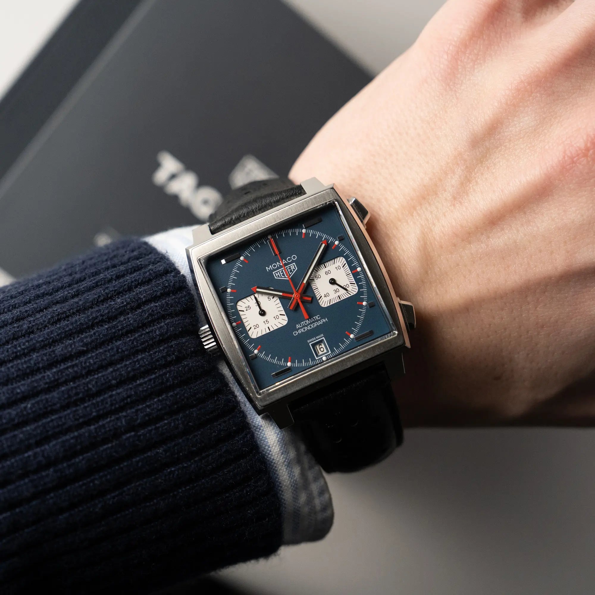 Wristshot mit dem Tag Heuer Monaco Calibre 11 Chronographen CAW211P mit dem klassischen blauen Zifferblatt und roten Details auf Ziegern und Indizes