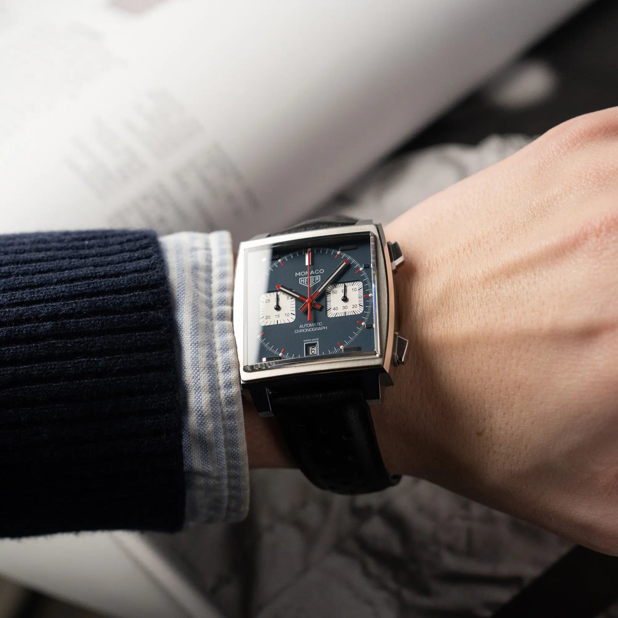 Wristshot mit dem Tag Heuer Monaco Calibre 11 Chronographen CAW211P mit dem klassischen blauen Zifferblatt und roten Details auf Ziegern und Indizes