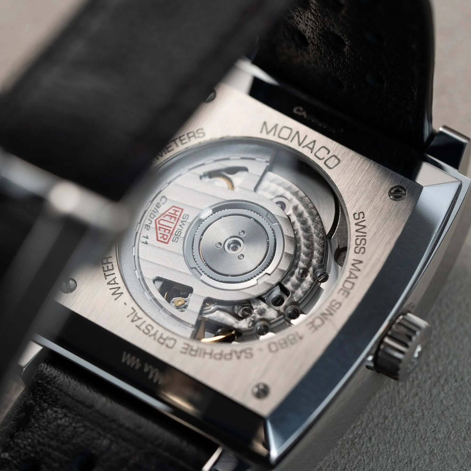 Gehäuseboden mit Sichtglas für einen optimalen Blick auf das Calibre 11 des Tag Heuer Monaco Chronographen CAW211P mit dem klassischen blauen Zifferblatt und roten Details auf Zeigern und Indizes