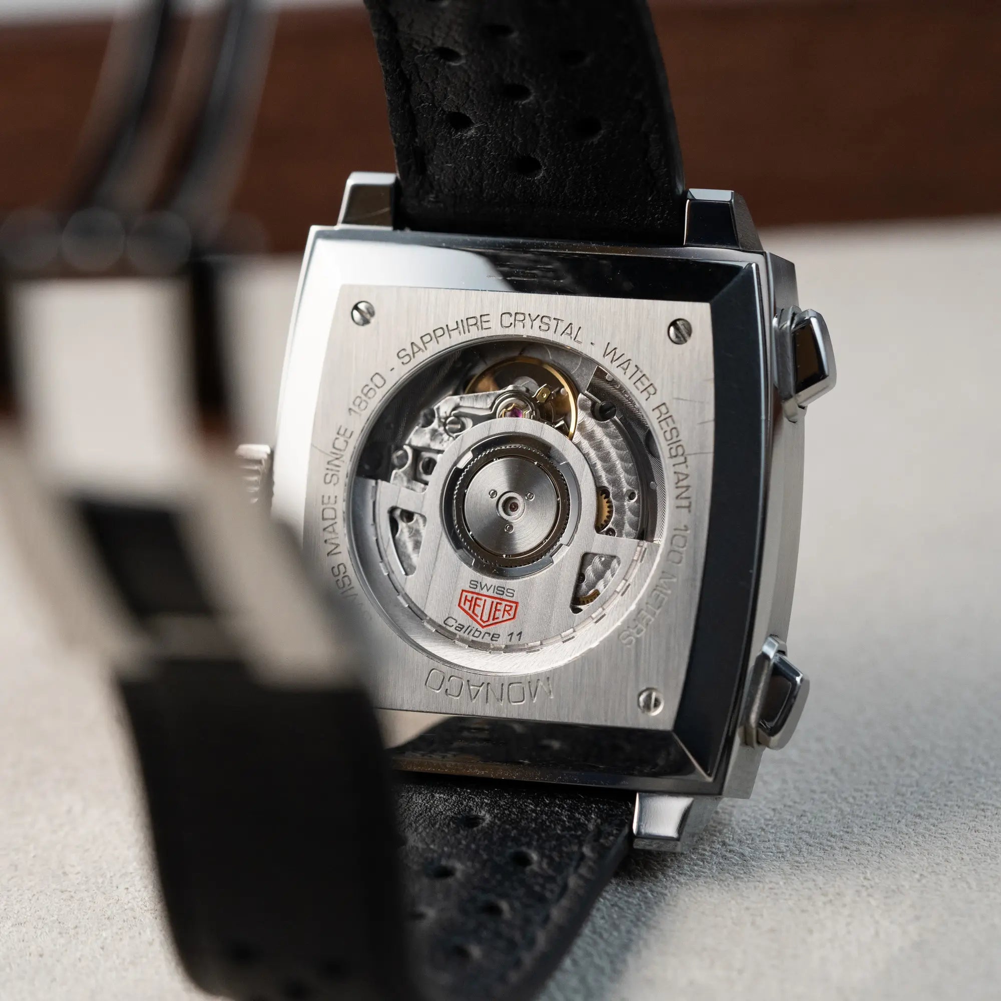 Gehäuseboden des Tag Heuer Monaco Calibre 11 Chronographen CAW211P mit dem klassischen blauen Zifferblatt und roten Details auf Zeigern und Indizes