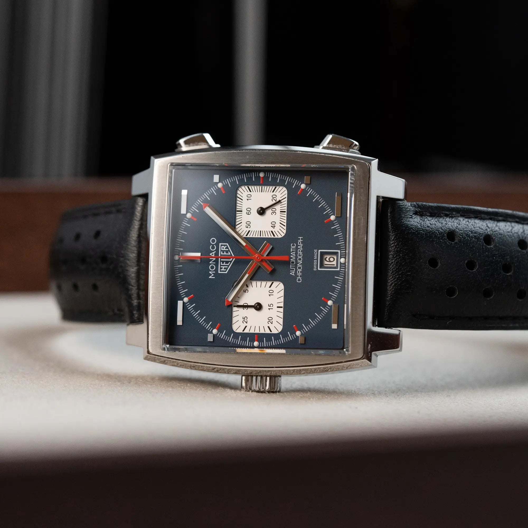 Produktfotografie des Tag Heuer Monaco Calibre 11 Chronographen CAW211P mit dem klassischen blauen Zifferblatt und roten Details auf Ziegern und Indizes