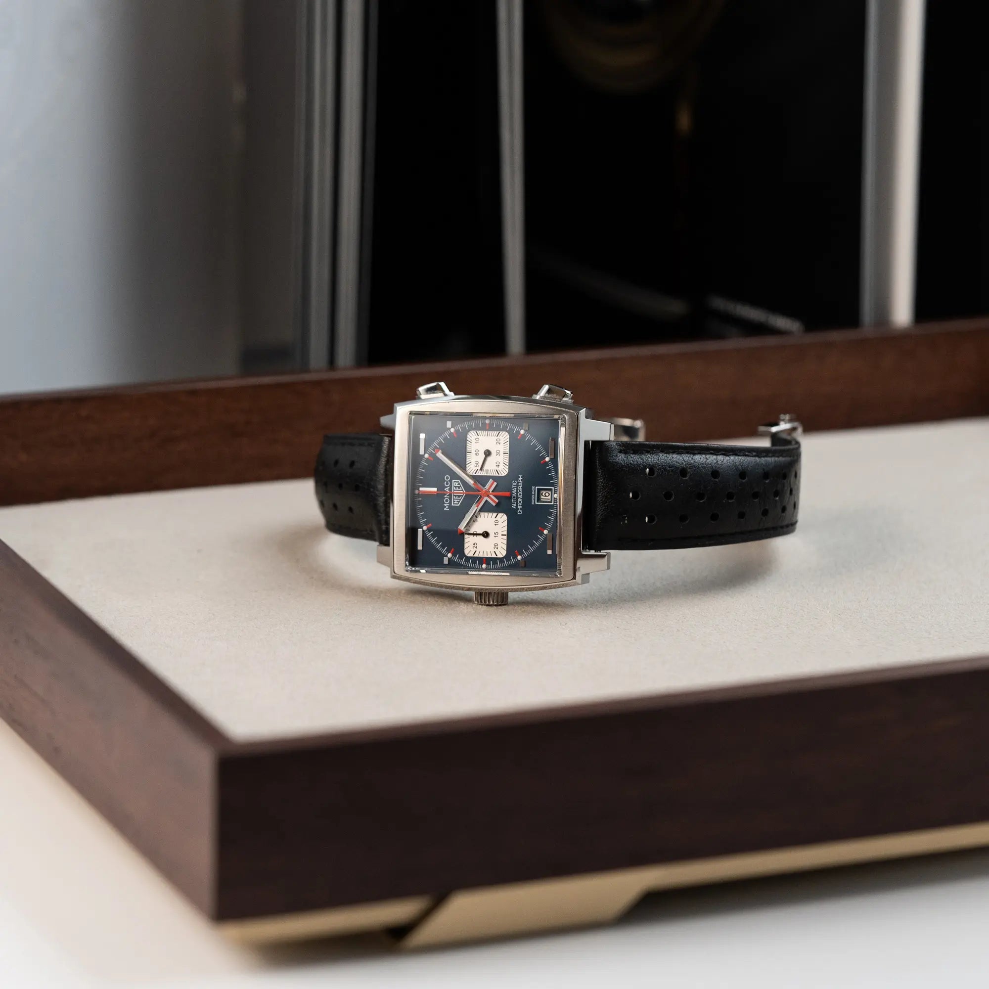 Produktfotografie des Tag Heuer Monaco Calibre 11 Chronographen CAW211P mit dem klassischen blauen Zifferblatt und roten Details auf Zeigern und Indizes