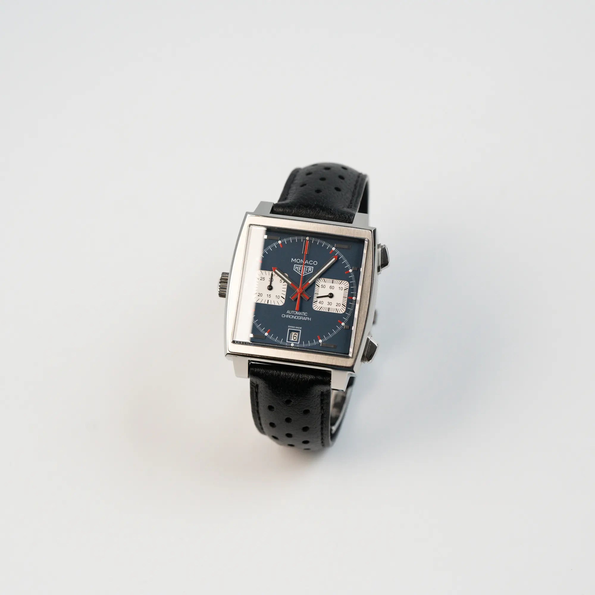 Leicht schräge Ansicht des Tag Heuer Monaco Calibre 11 Chronographen CAW211P mit dem klassischen blauen Zifferblatt und roten Details auf Ziegern und Indizes
