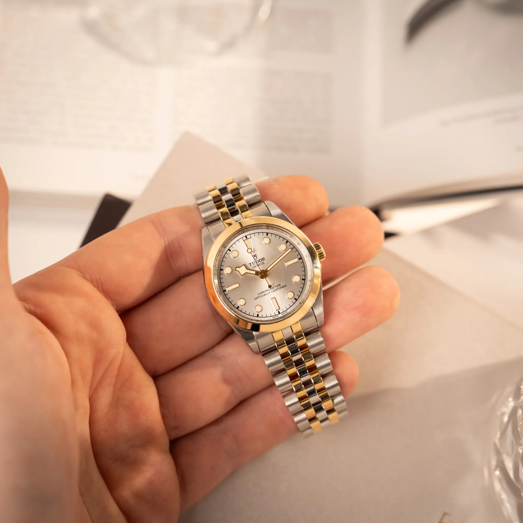 Mann hält die Tudor Black Bay 31 Stahl Gold der Referenz 79603 mit silberfarbenem Zifferblatt am Jubilee-Armband