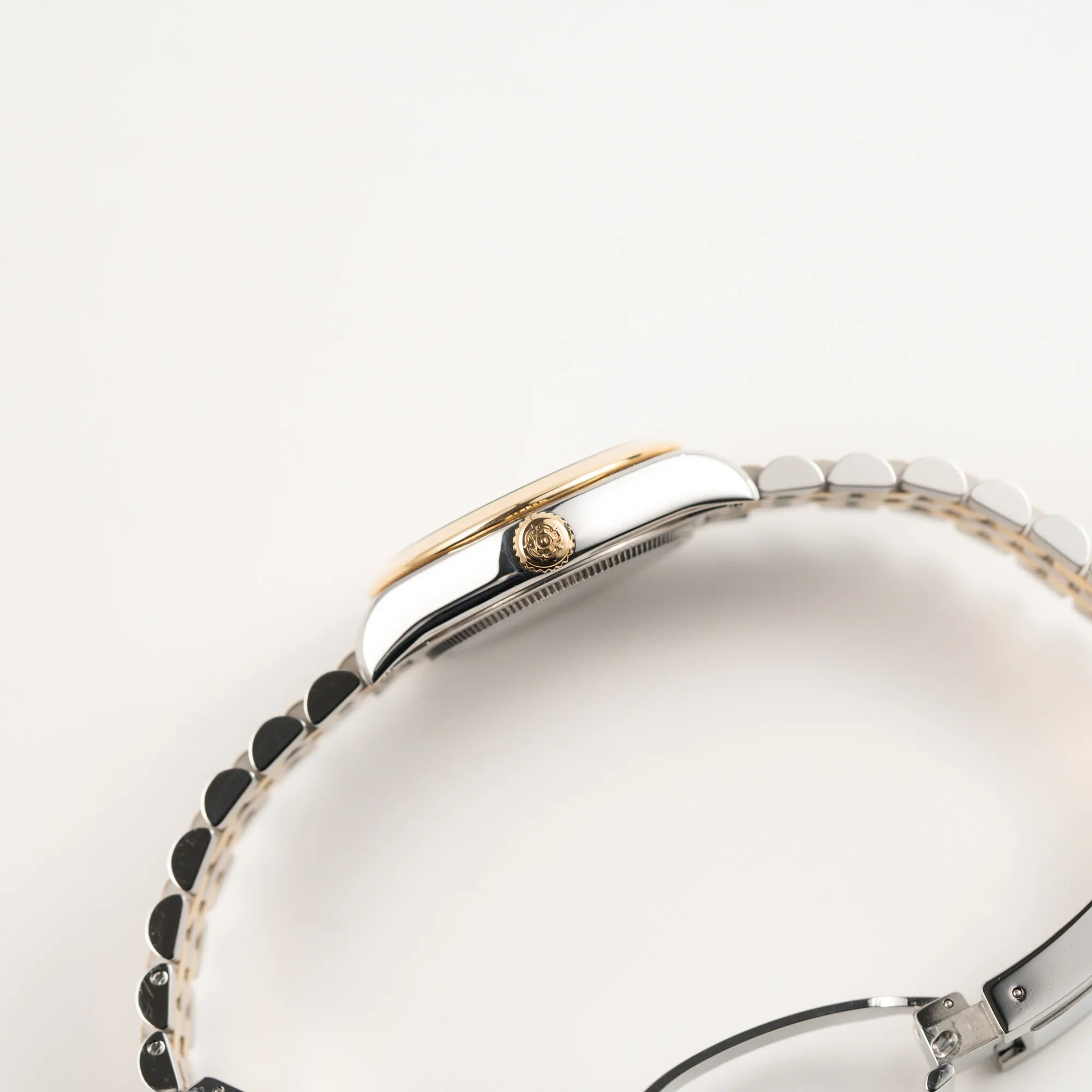 Seitliche Gehäuseflanke der Tudor Black Bay 31 Stahl Gold der Referenz 79603 mit silberfarbenem Zifferblatt am Jubilee-Armband mit Blick auf die Aufzugskrone