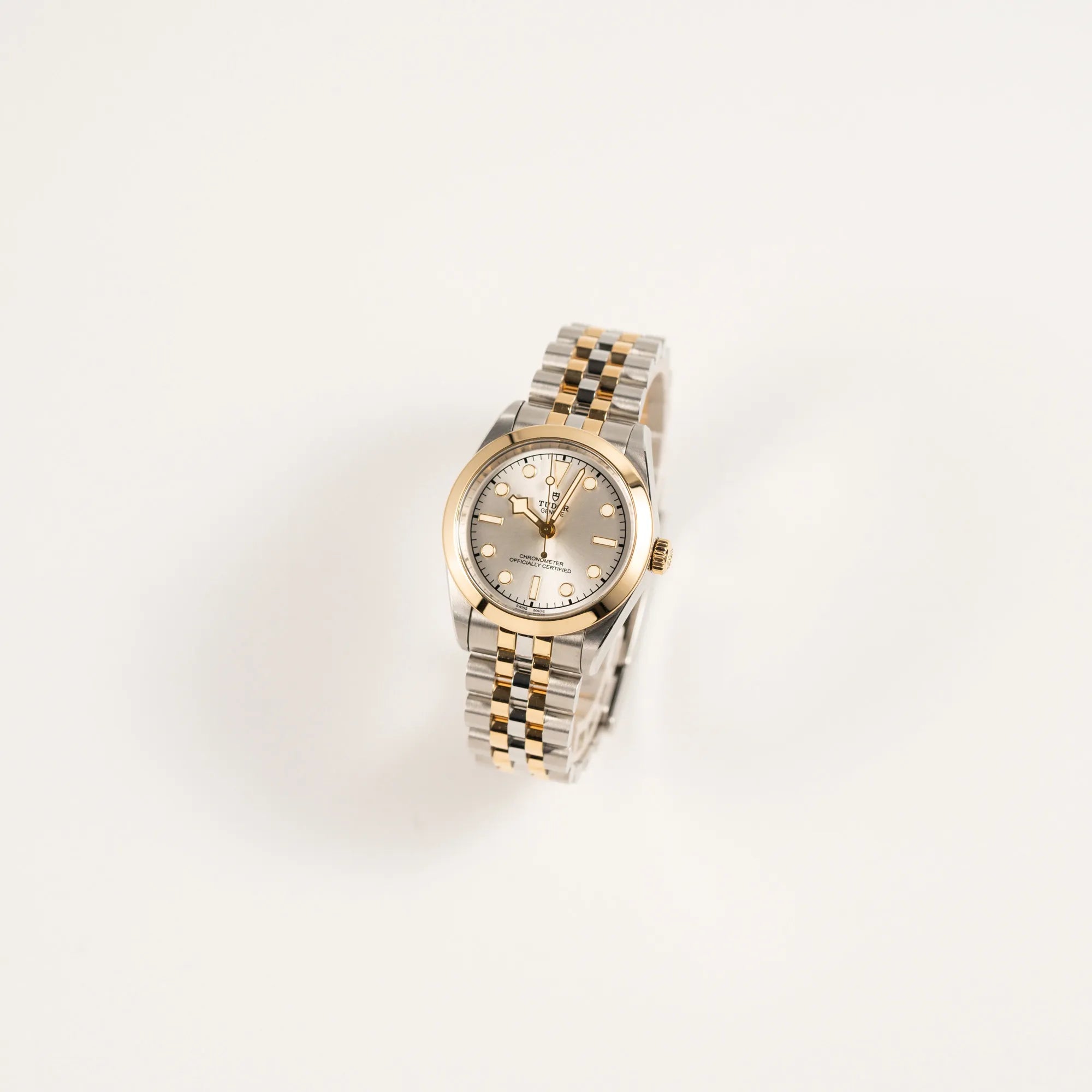 Leicht schräge Ansicht der Tudor Black Bay 31 Stahl Gold der Referenz 79603 mit silberfarbenem Zifferblatt am Jubilee-Armband