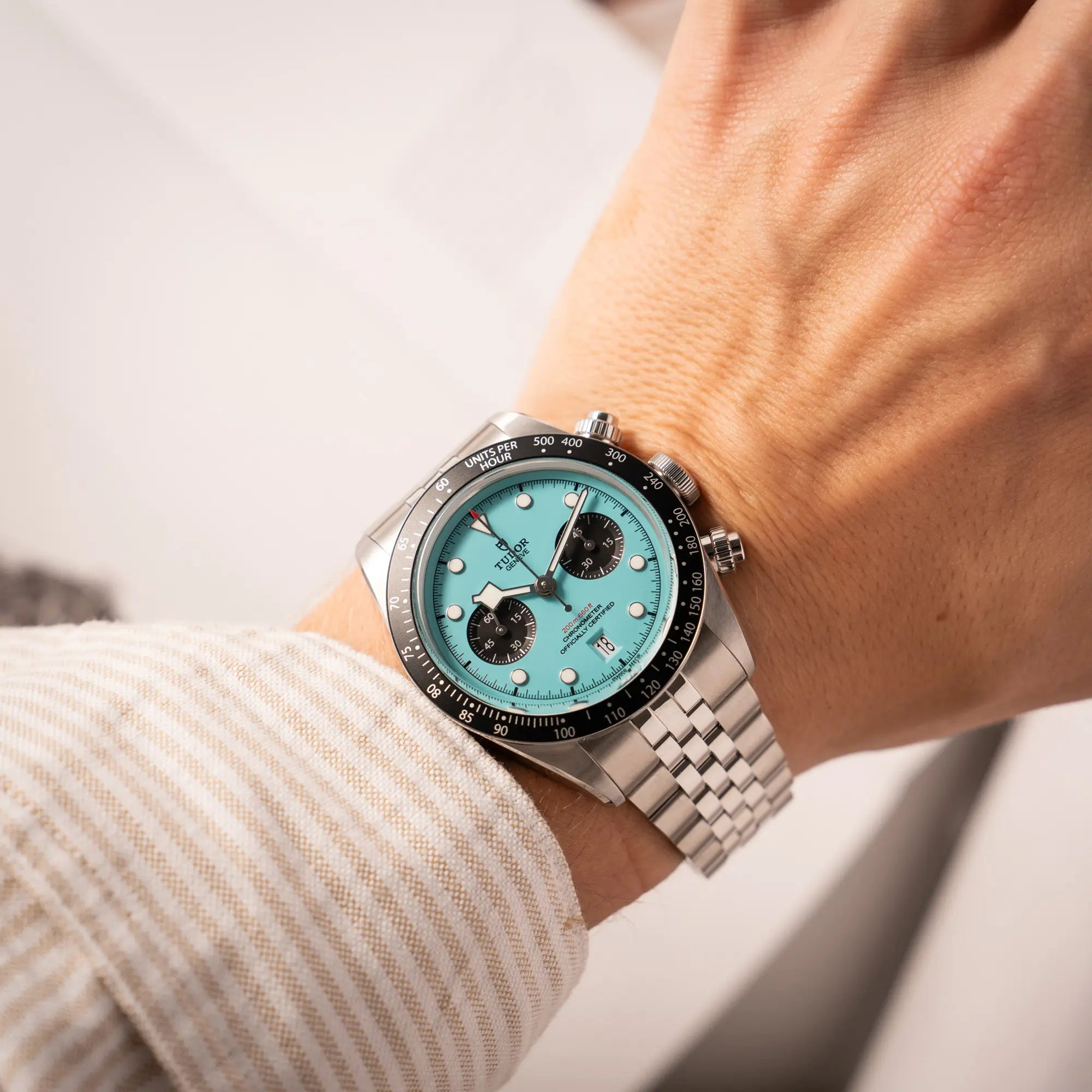 Mann präsentiert den Tudor Black Bay Chronograph Flamingo mit dem türkis-blauen Zifferblatt und schwarzer Lünette mit Zähler-Skala an seinem Handgelenk mit einem Wirstshot